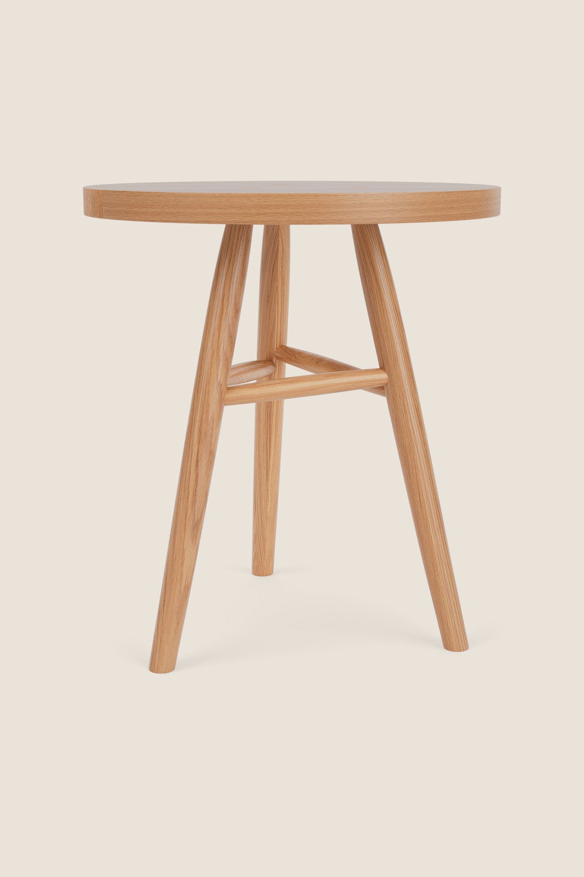 Round wooden Hudson Side Tables with three legs in white oak wood on beige background