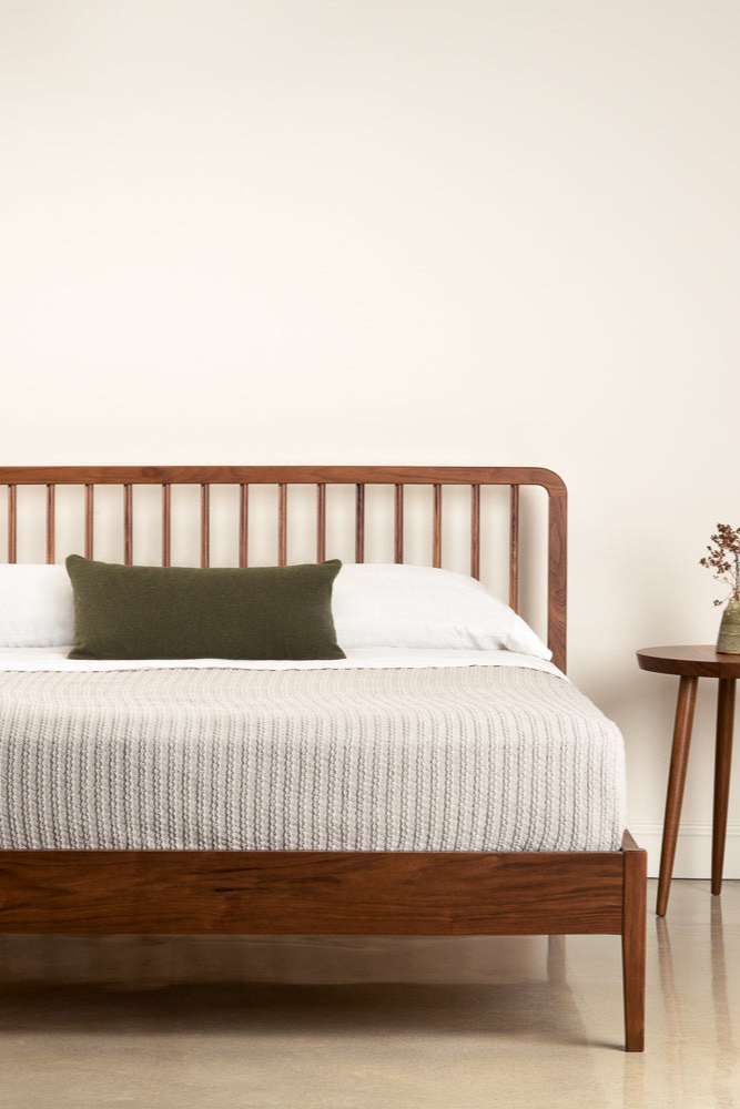 Modern Dune Spindle bed in walnut wood with three legged Mysa Nightstand