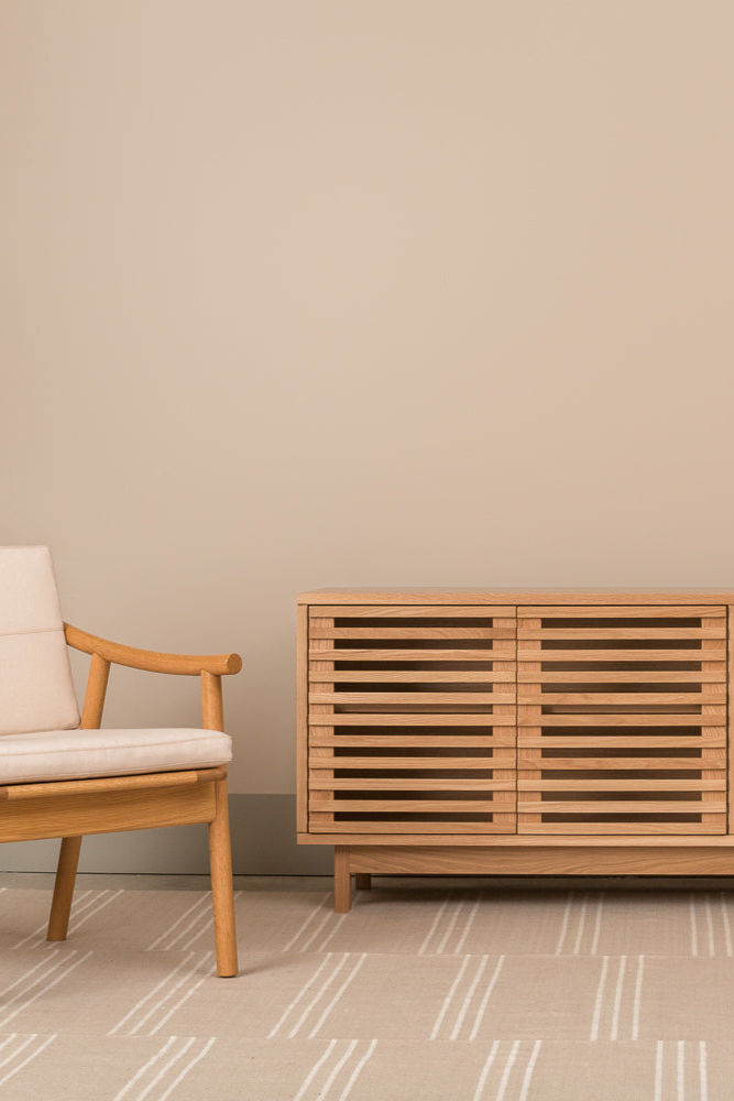 Modern minimalist living room with white oak Upland Media Stand and two Nautilis Loung Chairs for furniture, styled with tan rug