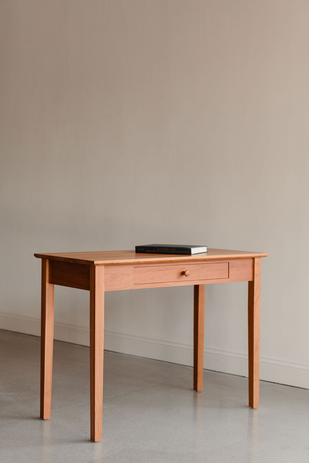 Wooden Shaker desk with a single drawer from Chilton Furniture against a plain wall.