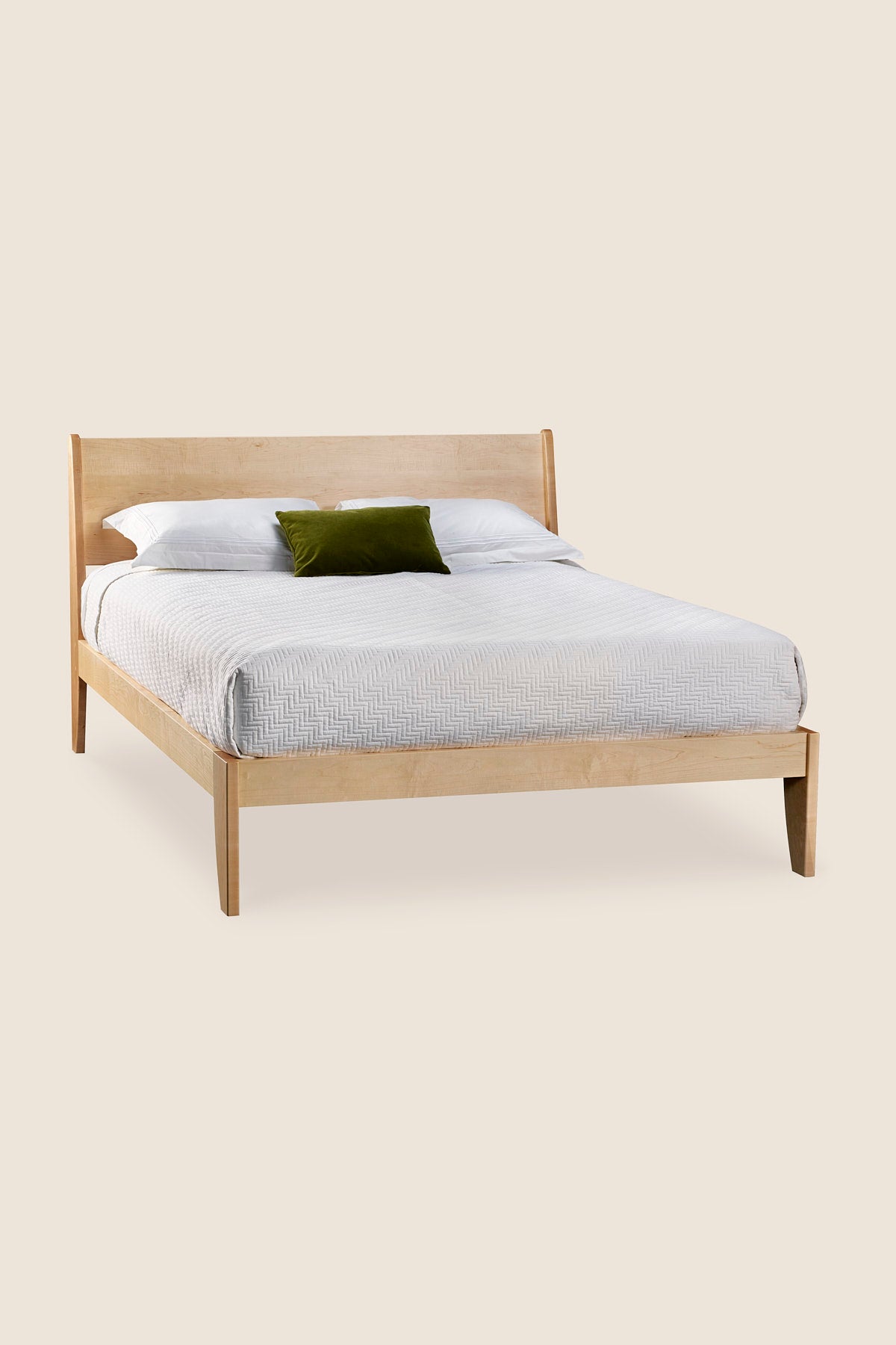 Modern sleigh bed in maple with low profile and white bedding, from Maine's Chilton Furniture Co.