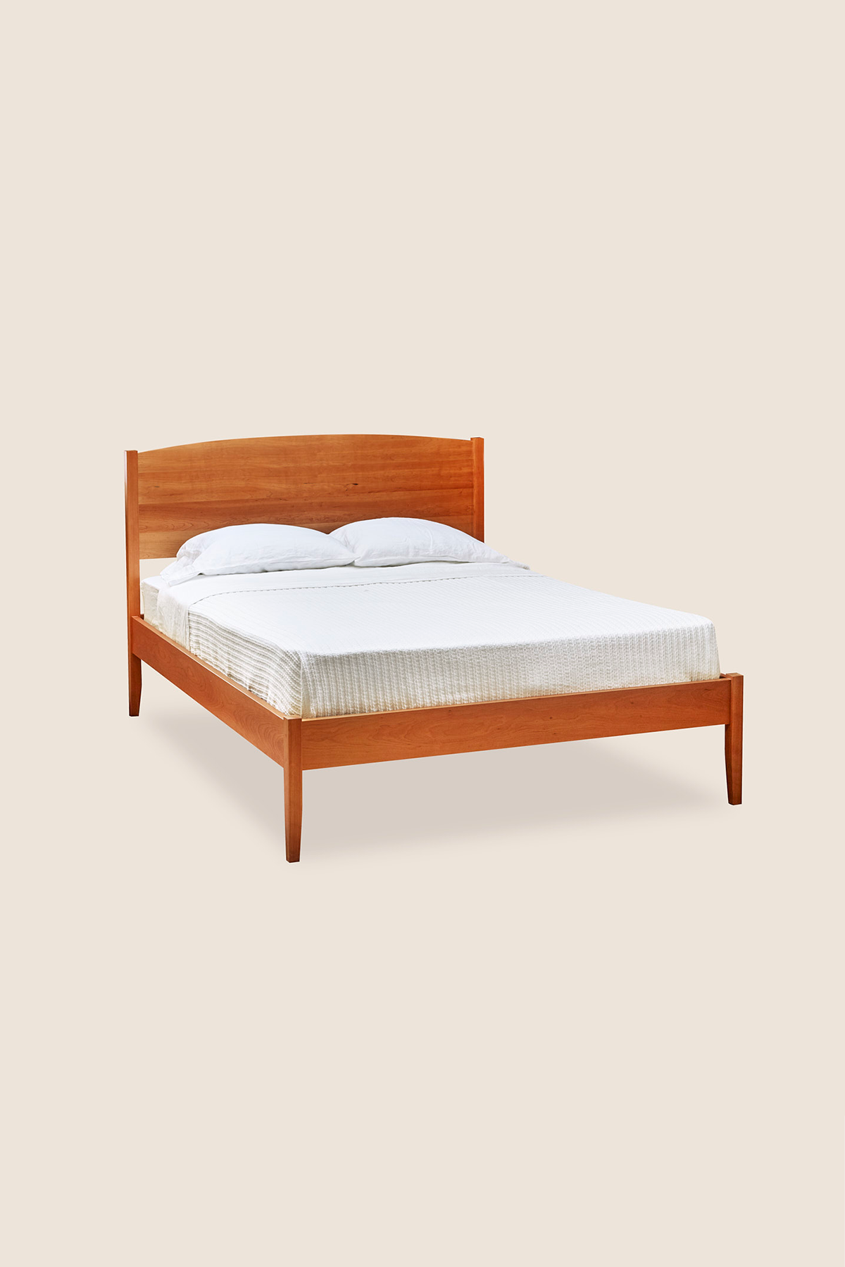 Shaker style, handmade solid cherry wood bed, with arched top and tapered legs, from Maine's Chilton Furniture Co.