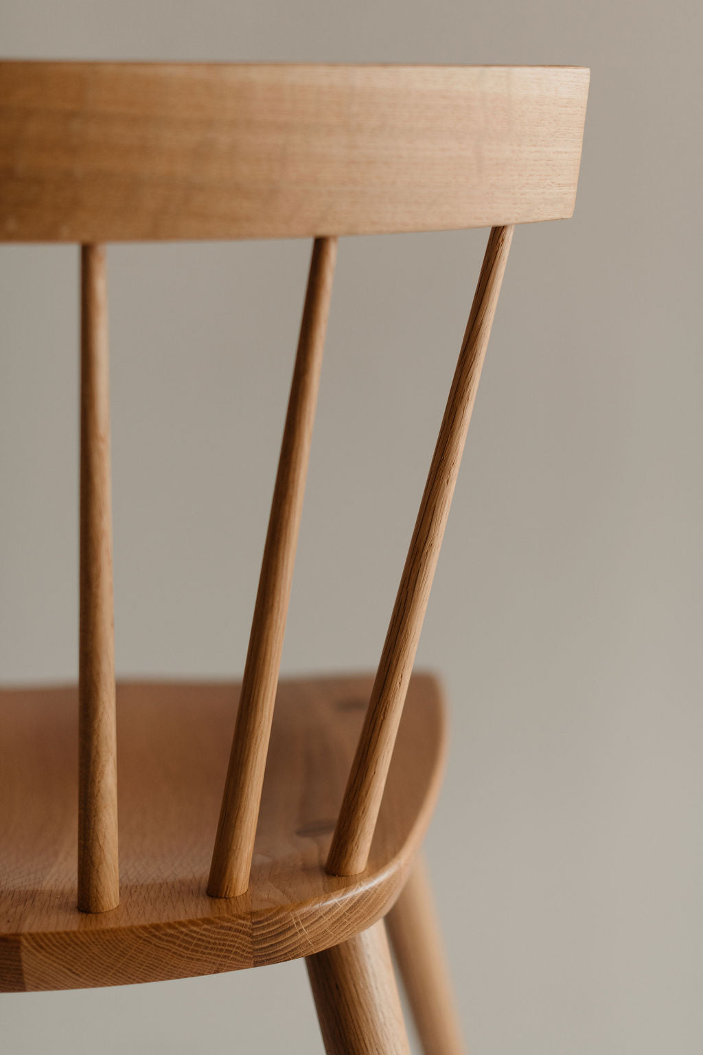 Close-up of a wooden chair with a neutral background