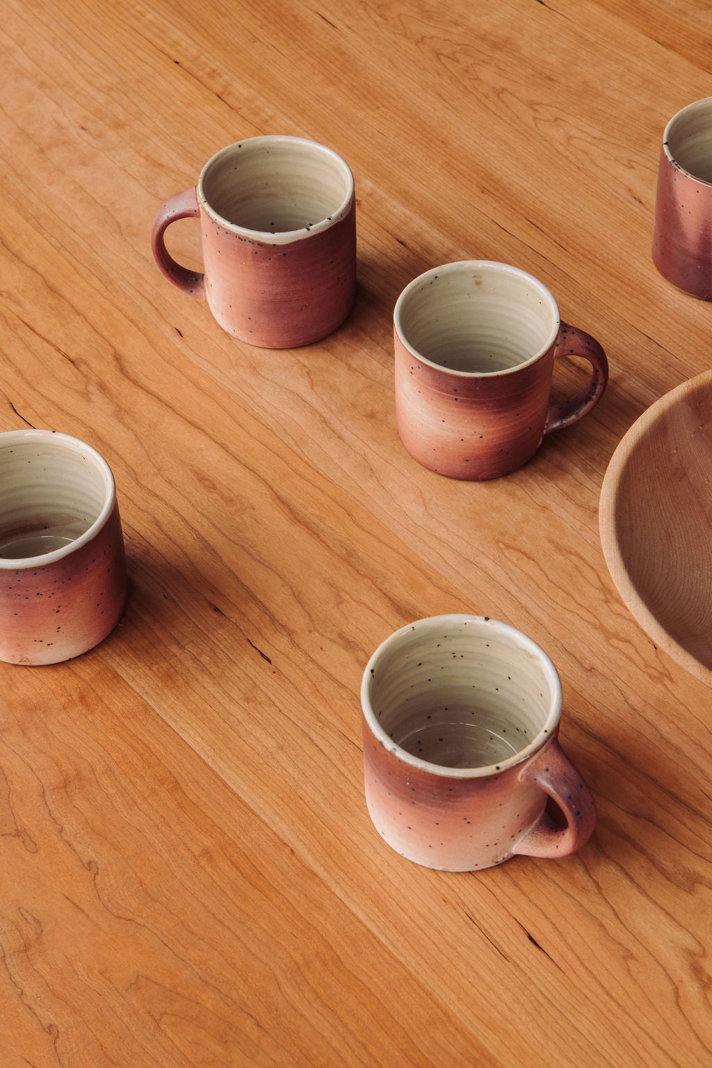 Set of ceramic mugs on a wooden surface