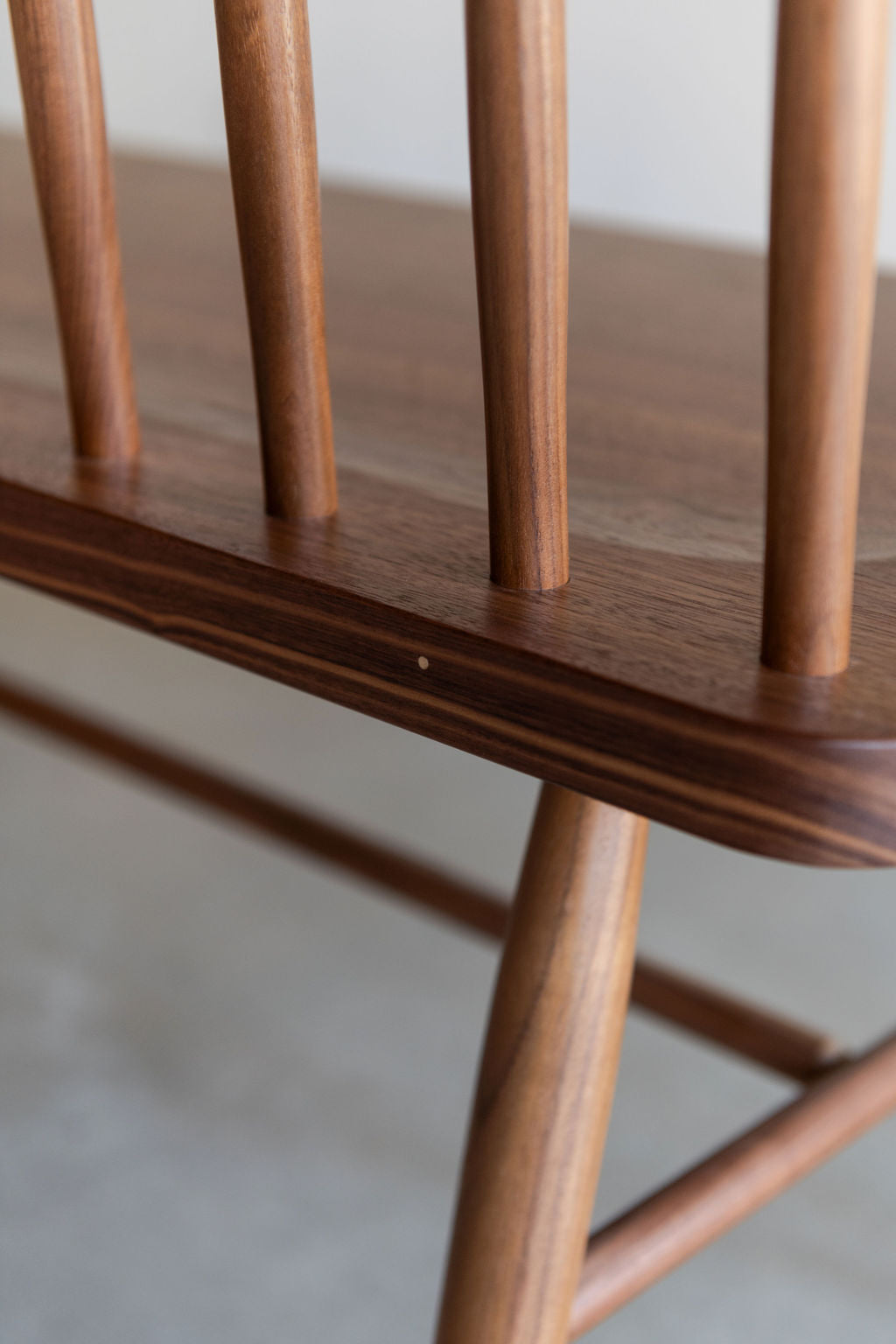 Detailed view of the curves and pegs on the traditional Shaker style spindle Broadside Bench