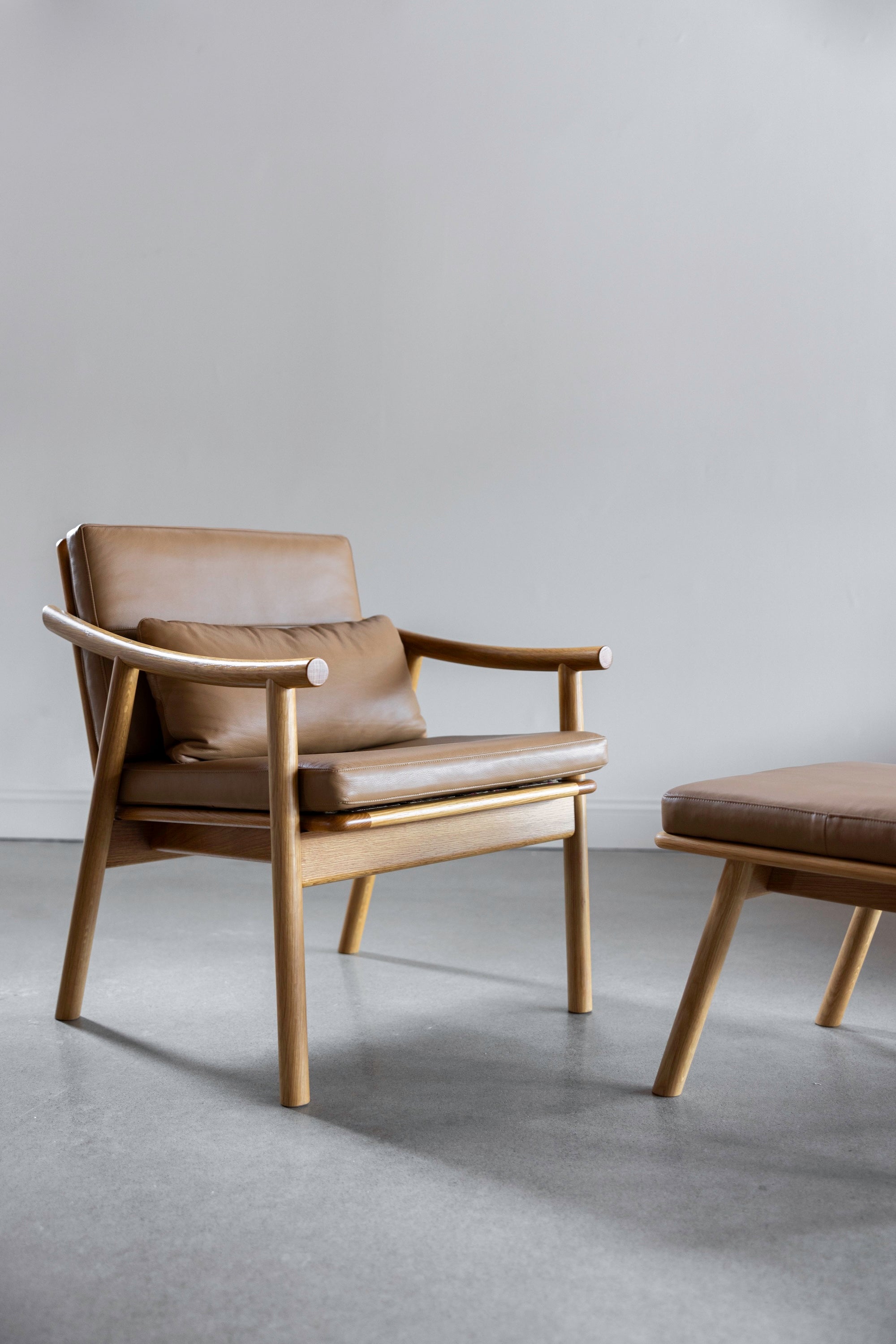 Solid white oak wood Scandinavian style Nautilus Ottoman and Lounge Chair with leather cushions from Maine's Chilton Furniture Co.