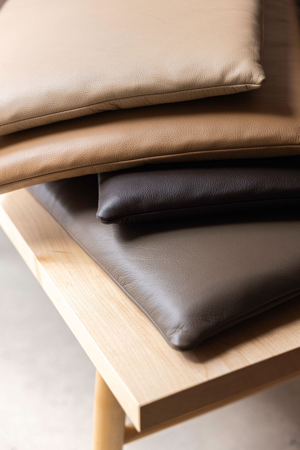 Brown leather cushions on a wooden bench