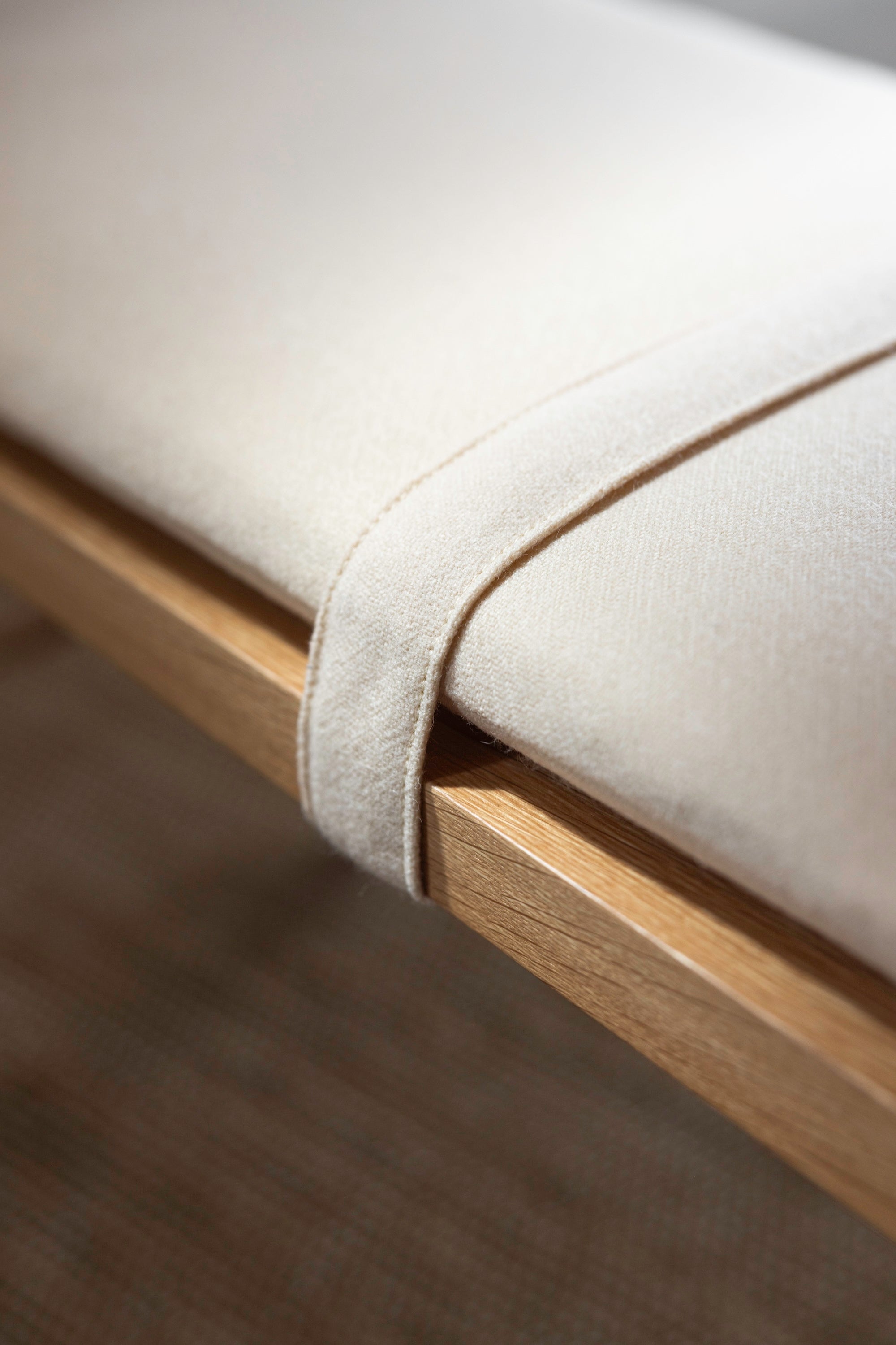 Detachable strap to hold fabric cushion on white oak bench