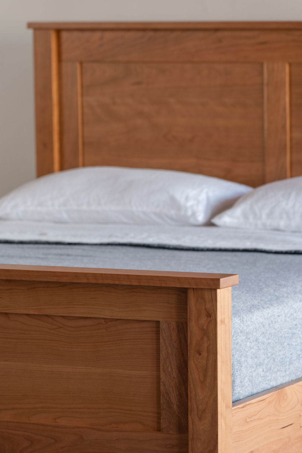 Traditional Shaker style cherry bed with focus on high footboard