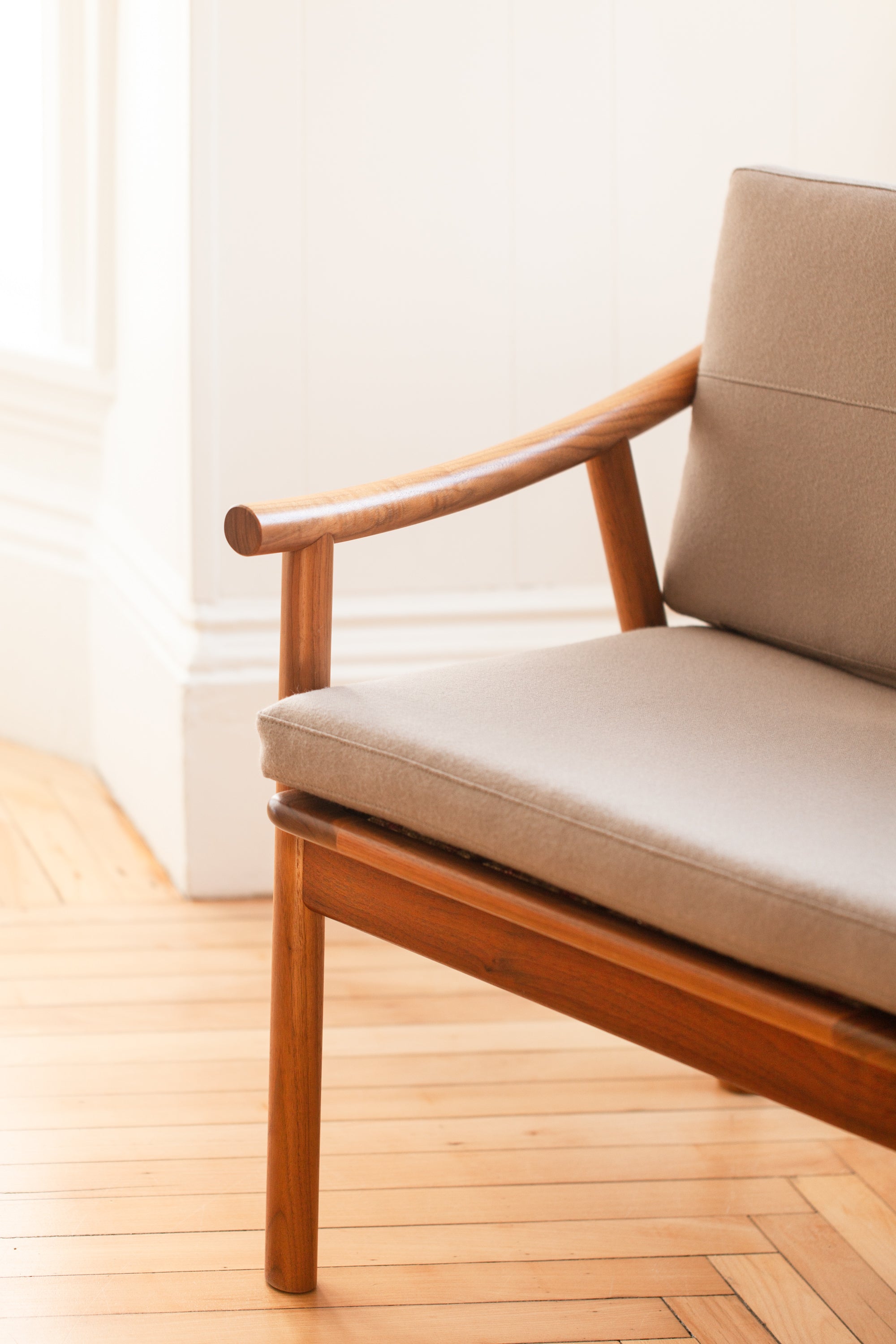 Joinery on arms of Nautilus Lounge Chair in bright white room with wood floors