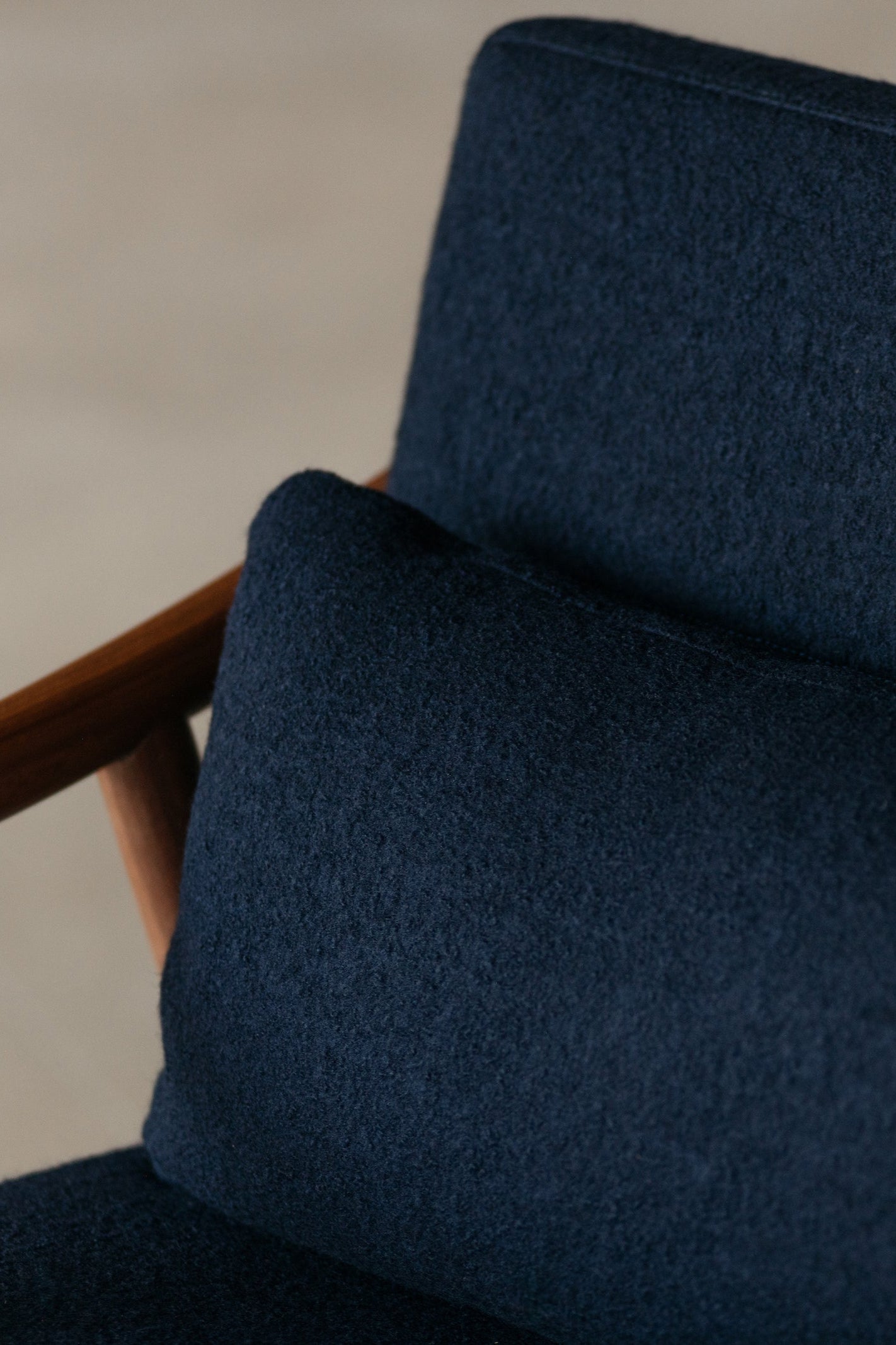 Nautilus Lounge Chair and lumbar pillow with dark blue boucle fabric