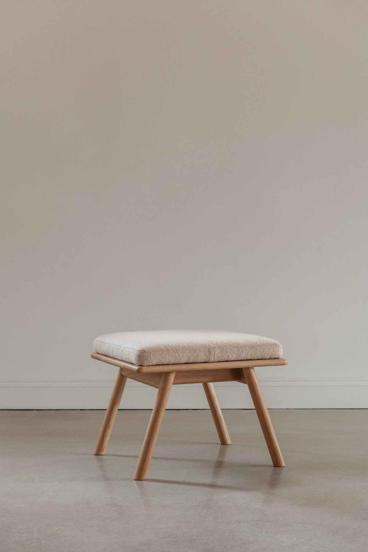White Oak wood Scandinavian style Nautilus Ottoman with boucle fabric cushions, from Maine's Chilton Furniture Co.