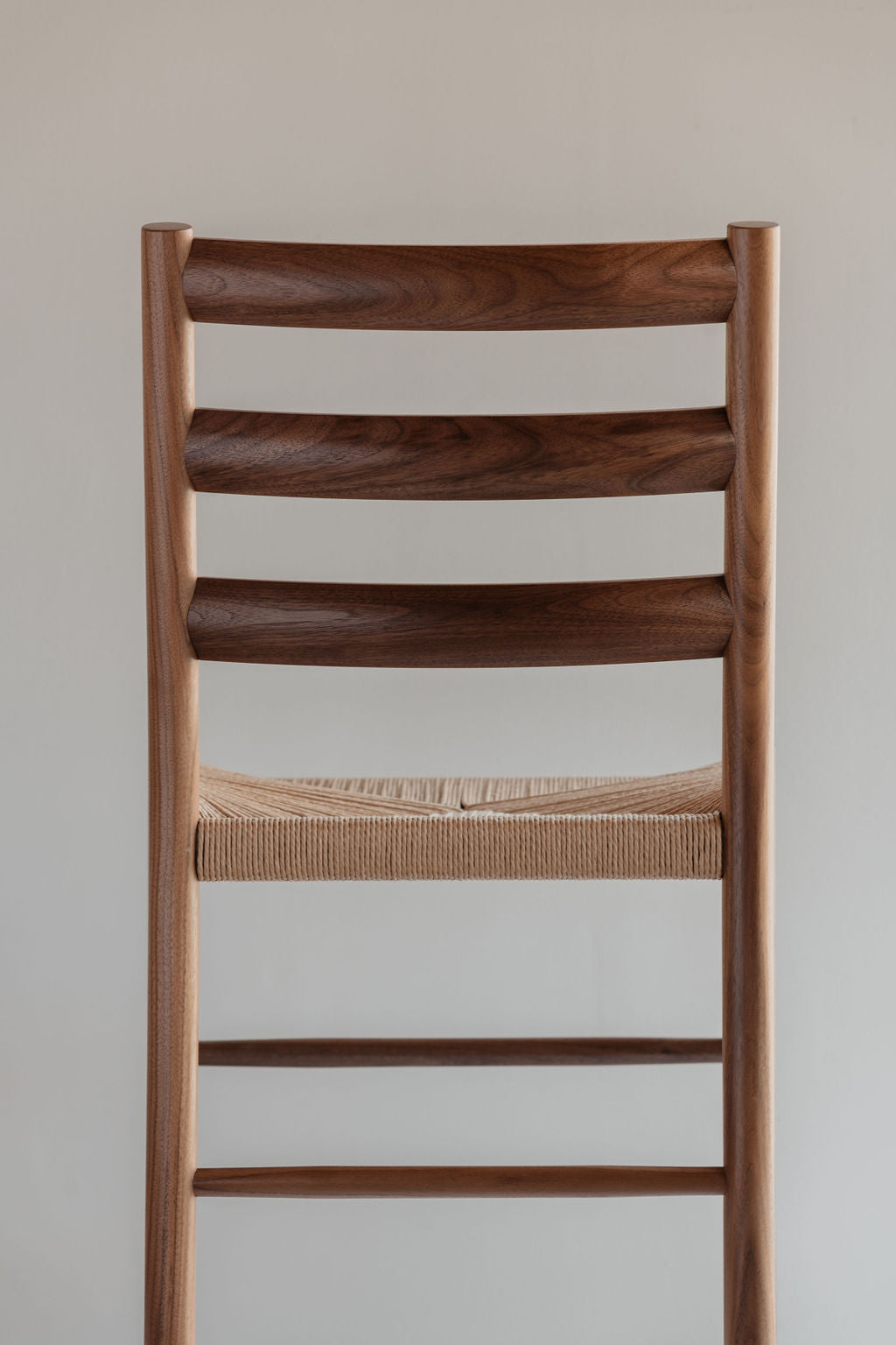 Knox ladder back chair with woven danish cord seat in walnut wood photographed from the back