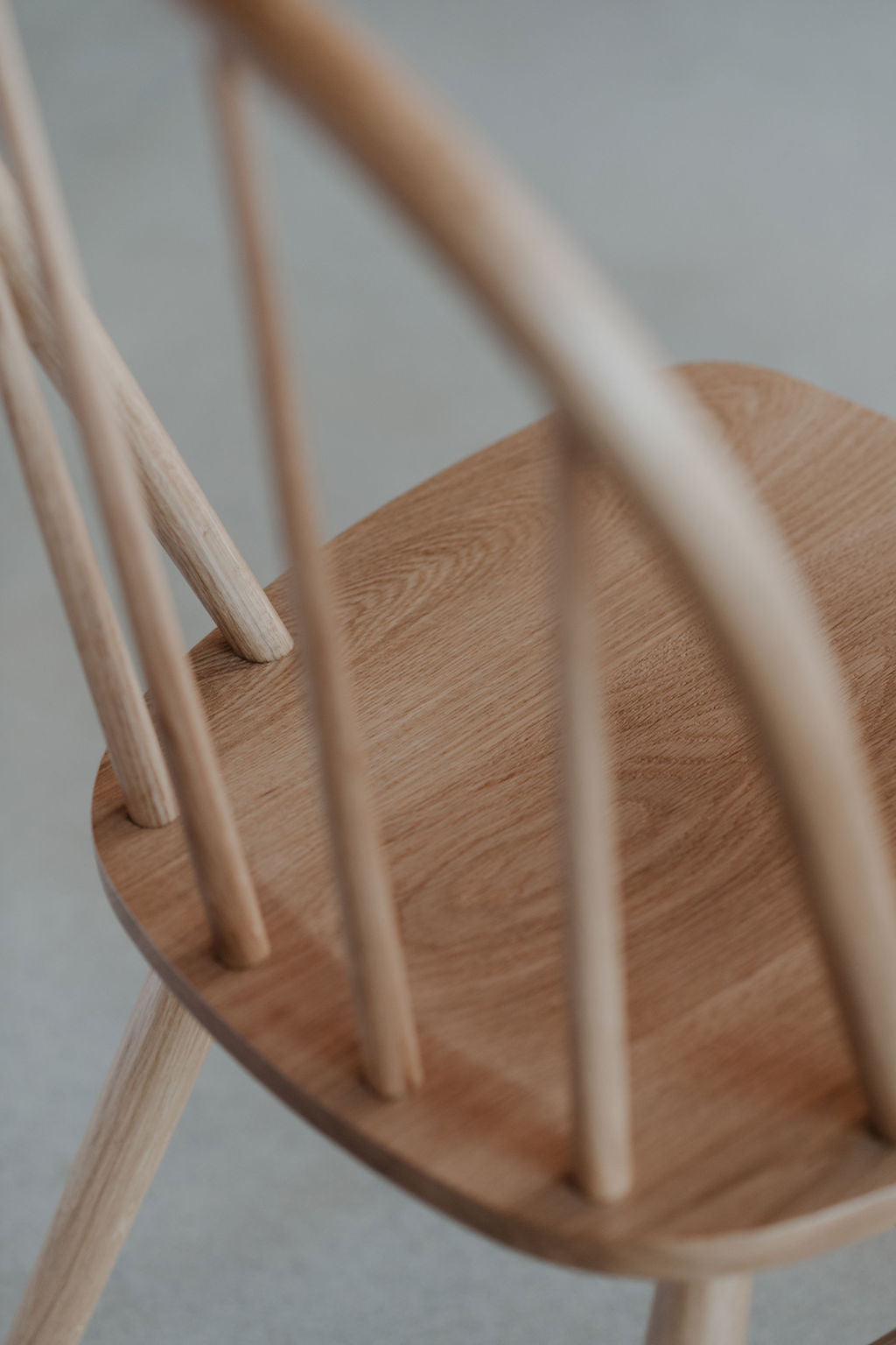 Details of spindles meeting the seat on the Hudson Chair in light white oak wood