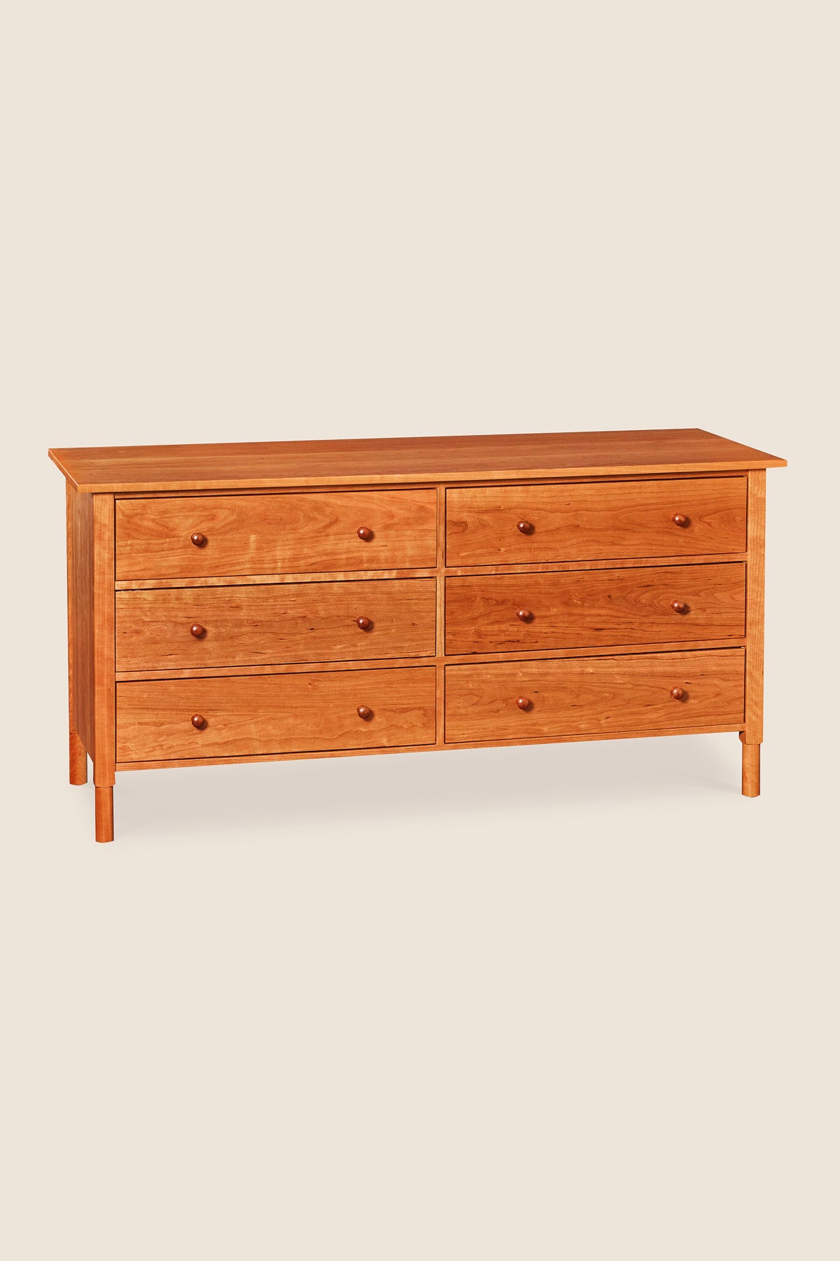 Modern interpretation of a classic Shaker style dresser with six drawers and rounded legs, in solid cherry wood