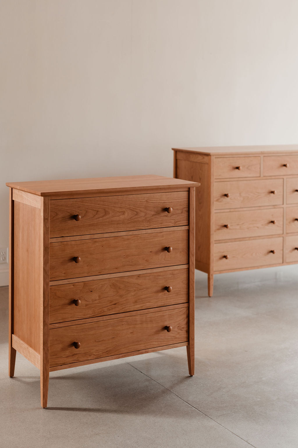 two wooden dressers with multiple drawers on a neutral background