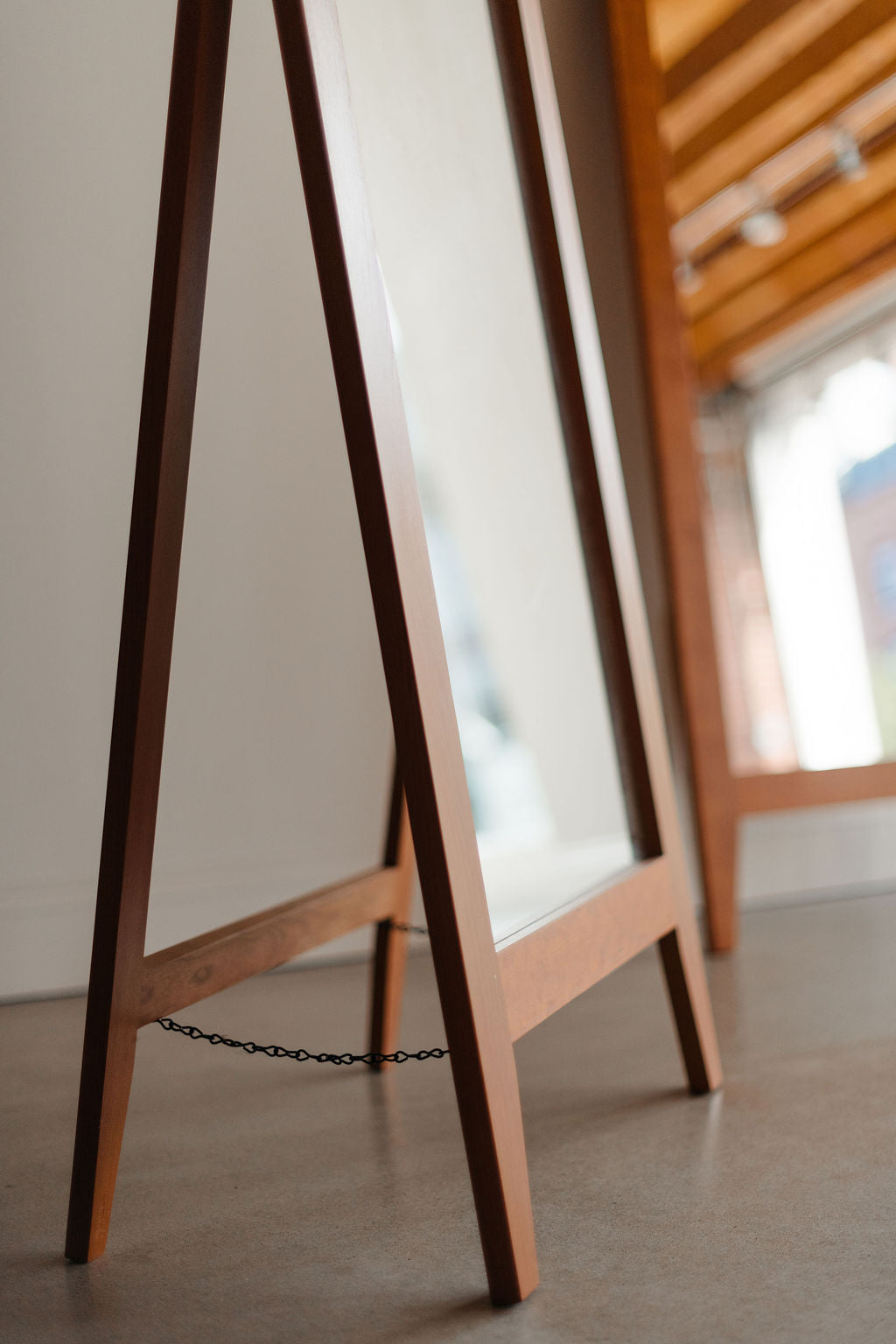 Wooden easel with a chain on a neutral background