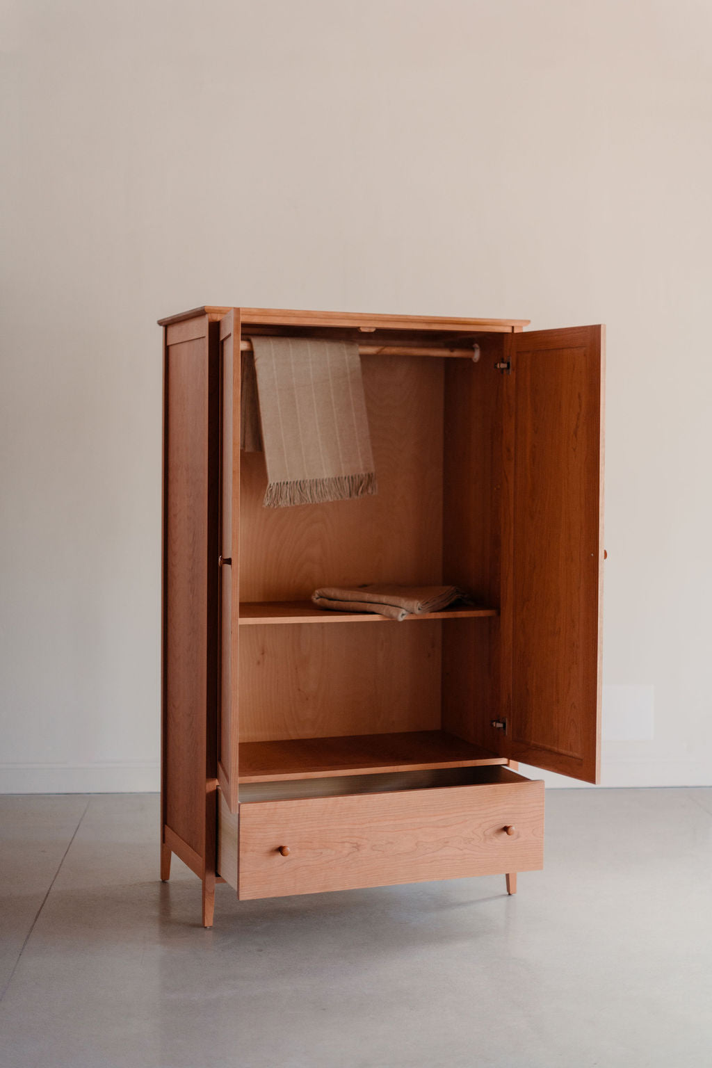 Wooden wardrobe with open doors on a plain background