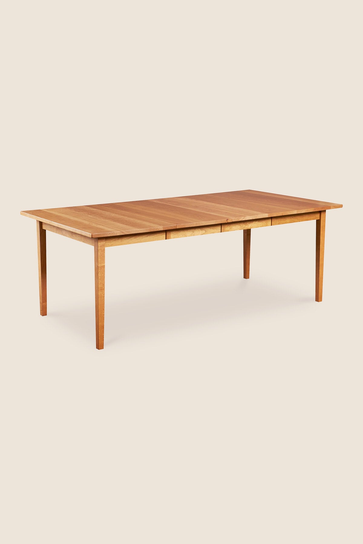 Solid cherry wood extension table with two leaves and tapered Shaker legs from Maine's Chilton Furniture Co.