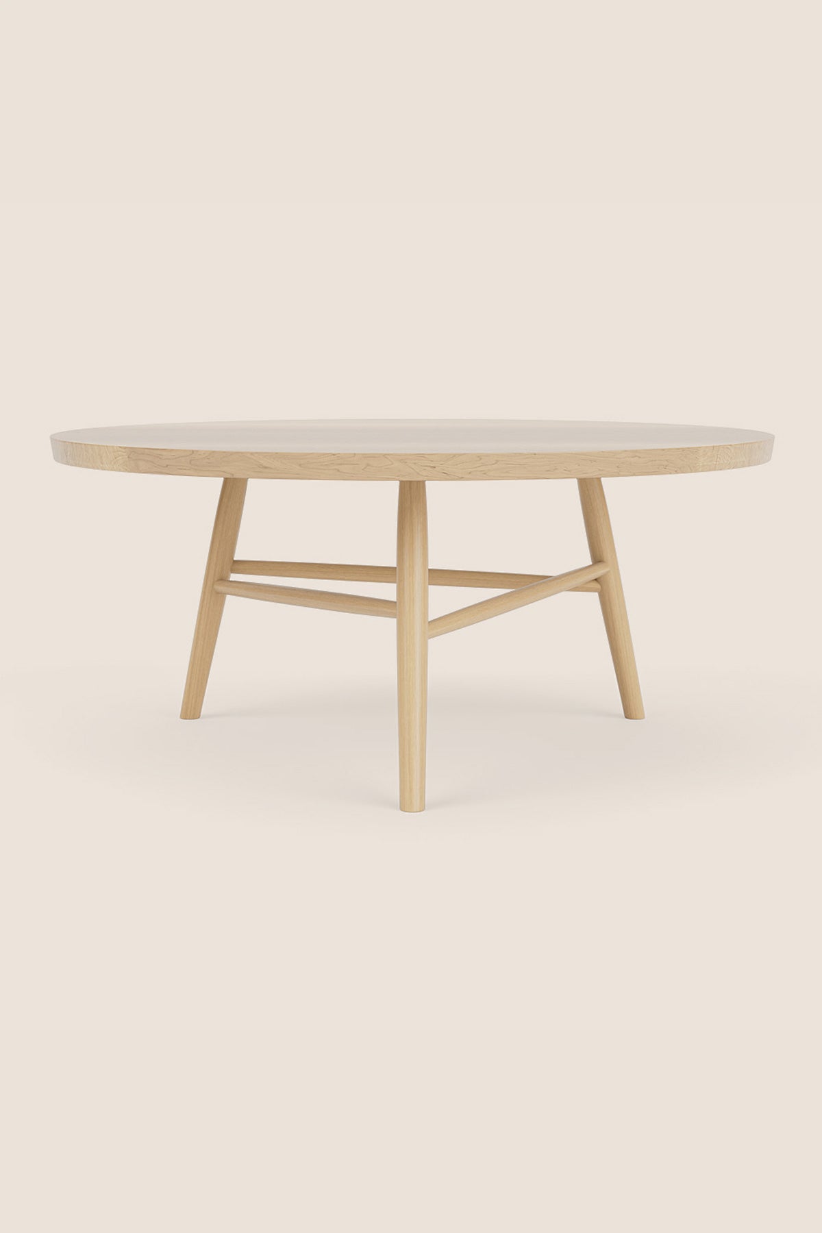Round wooden Hudson Coffee Table in maple with three legs on beige background