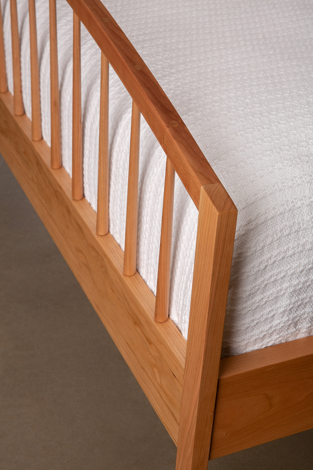 Mortise and tenon joinery on arched footboard of Burnette Spindle Bed