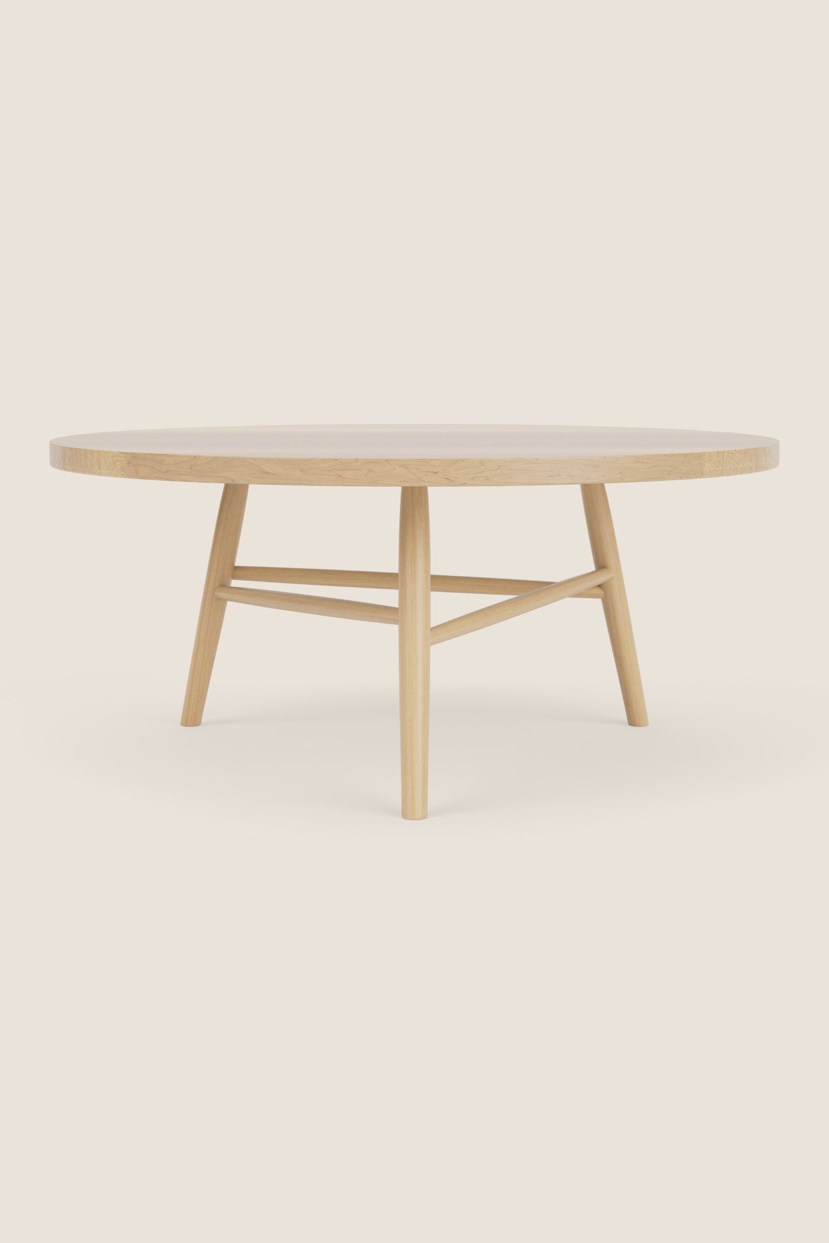 Round wooden Hudson Coffee Table with three legs on beige background
