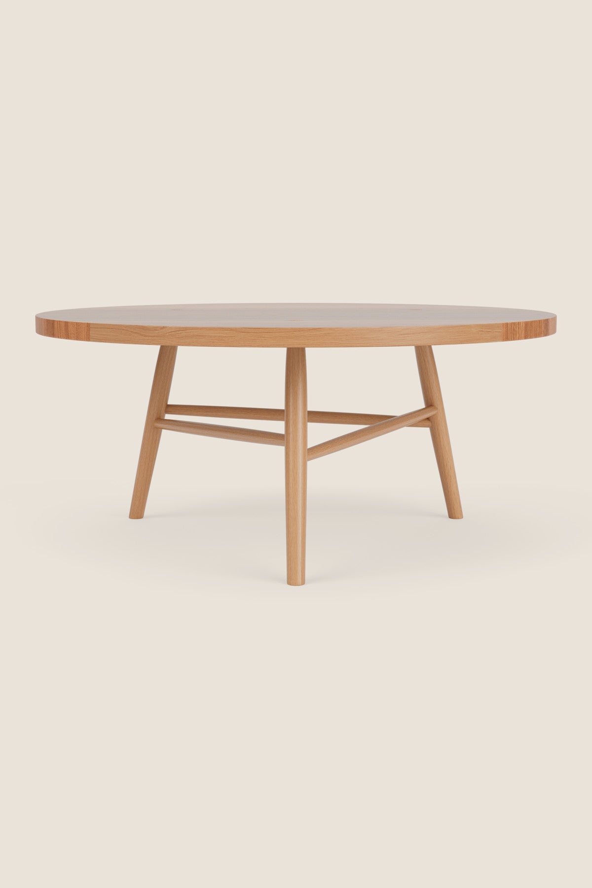 Round wooden Hudson Coffee Table with three legs on beige background