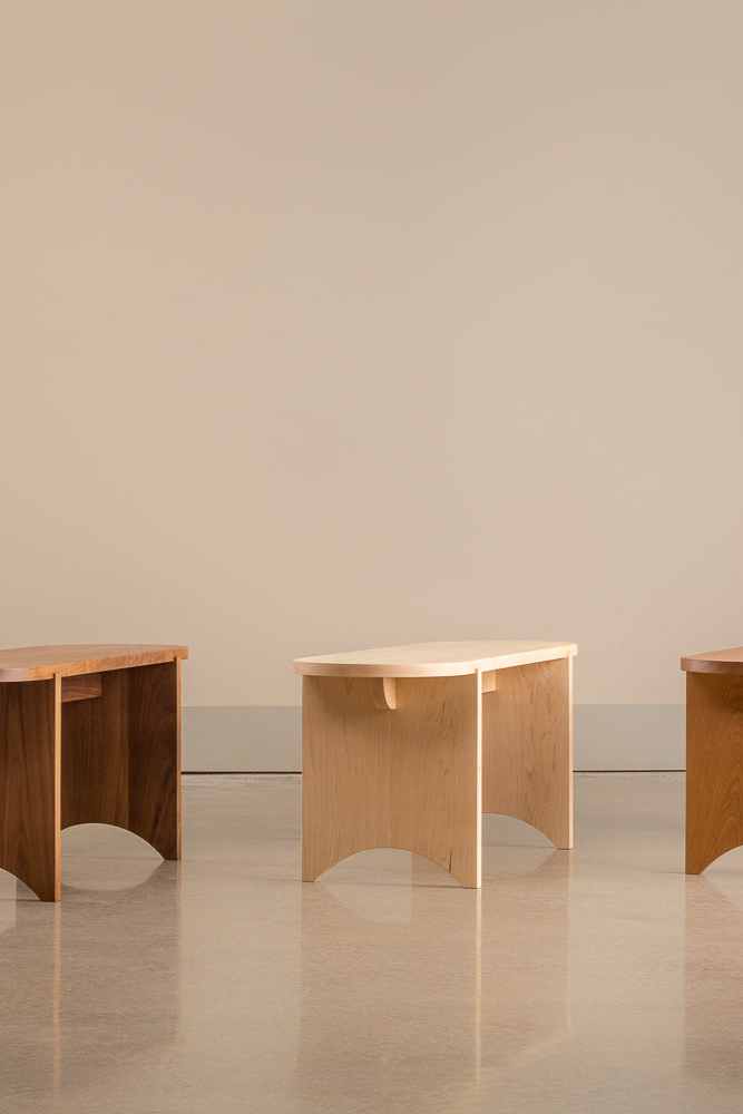 Three oval Portland Bench's lined up in different woods: white oak, walnut, maple and cherry