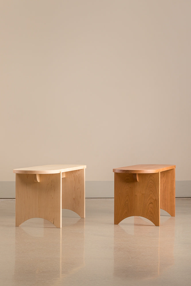 Two oval Portland Bench's lined up in different woods: white oak, walnut, maple and cherry