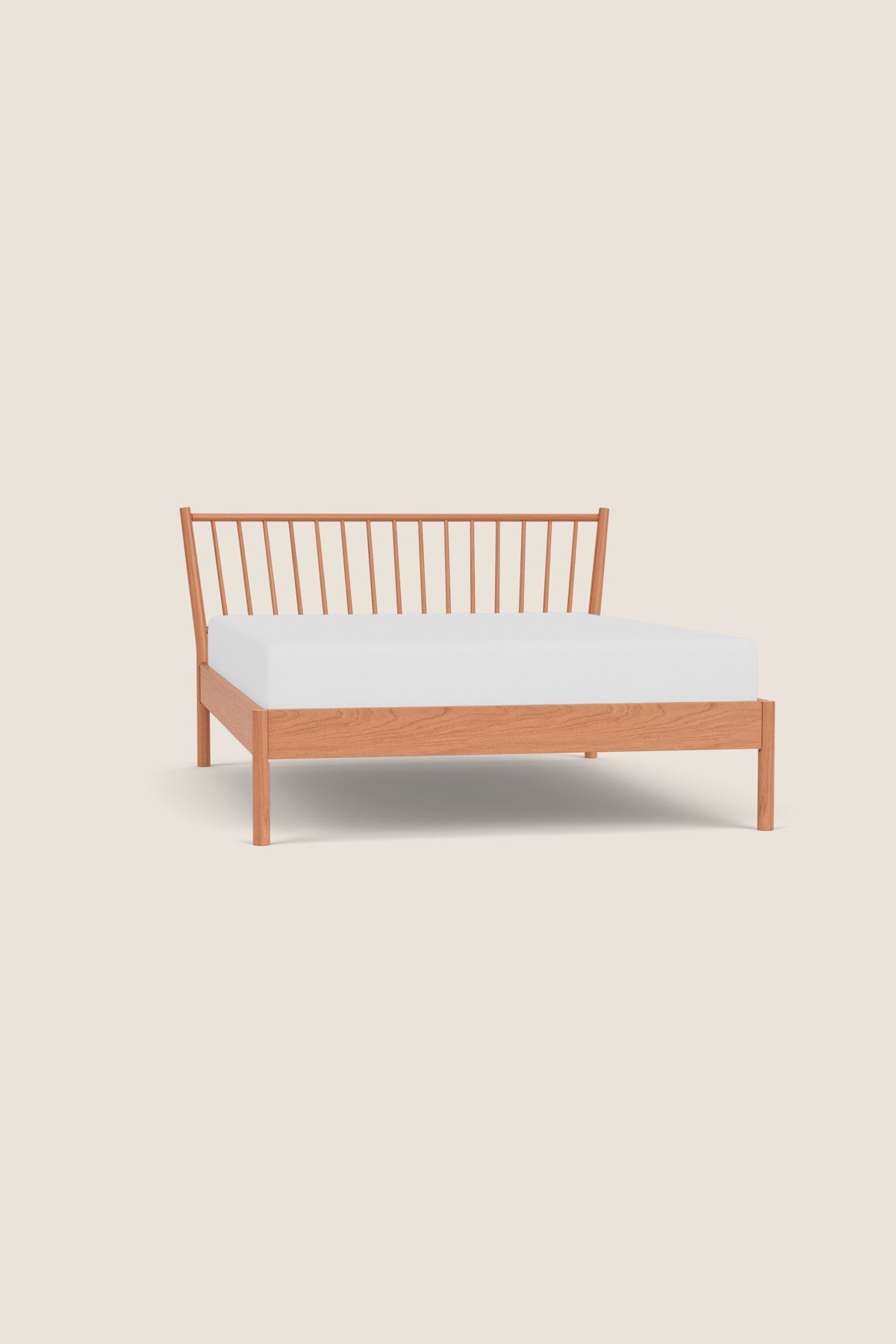 Wooden bed frame with white mattress on a beige background