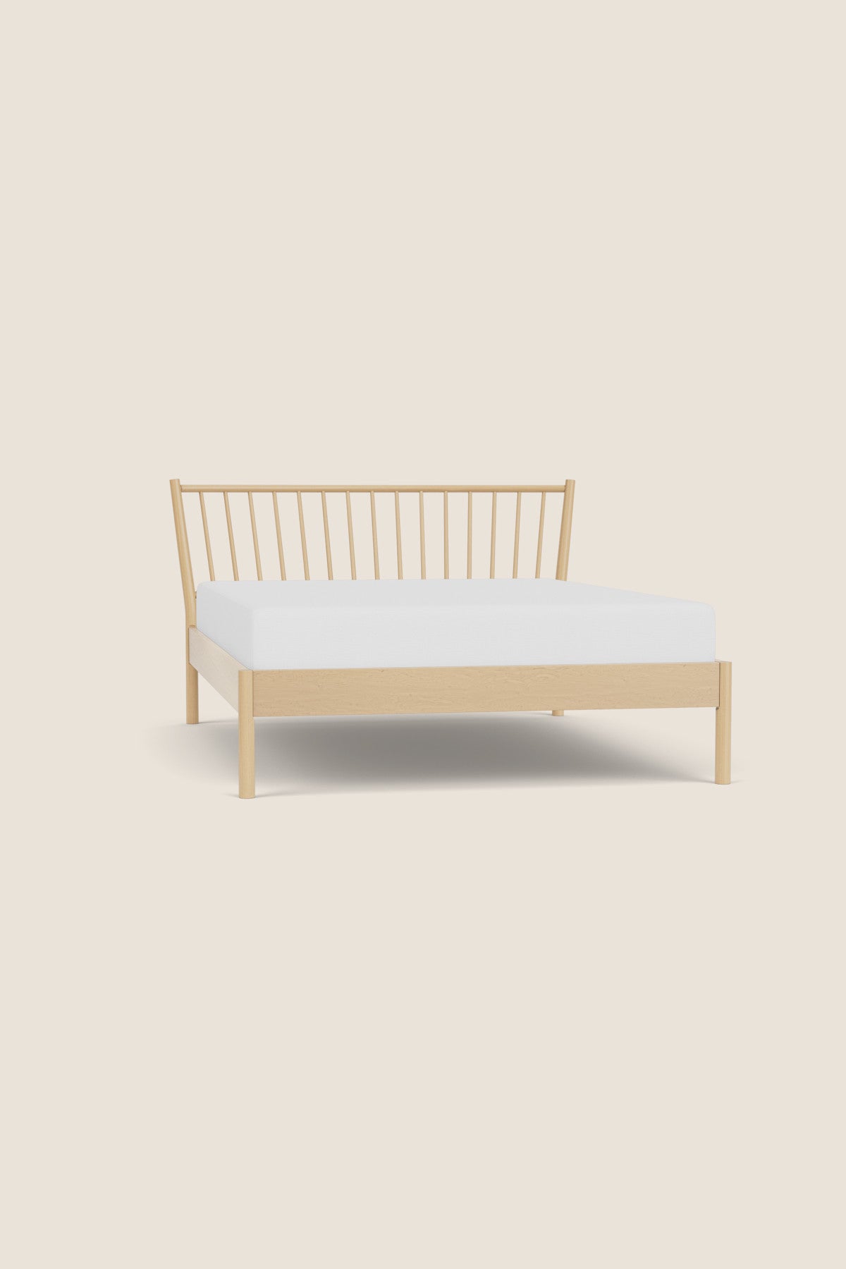 Wooden bed frame with white mattress on a beige background