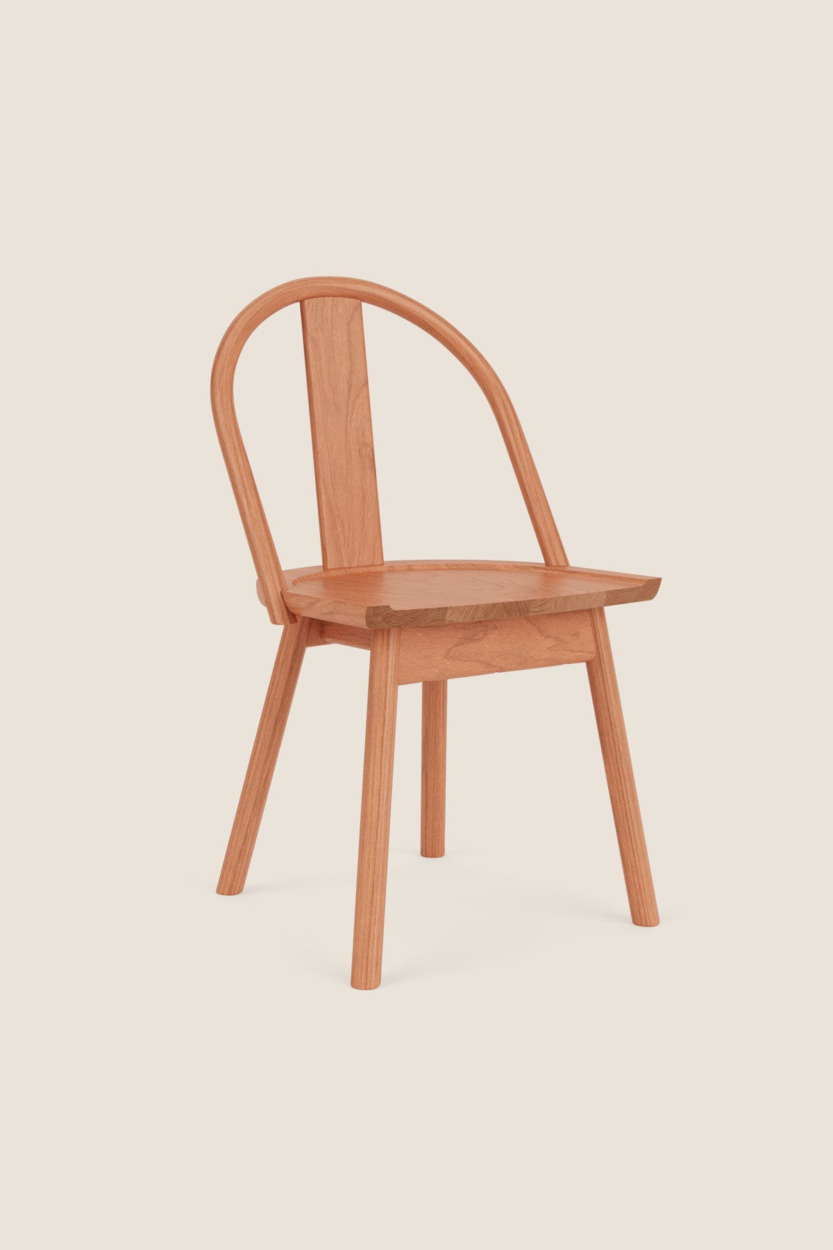 A modern version of a traditional bowback chair in cherry wood