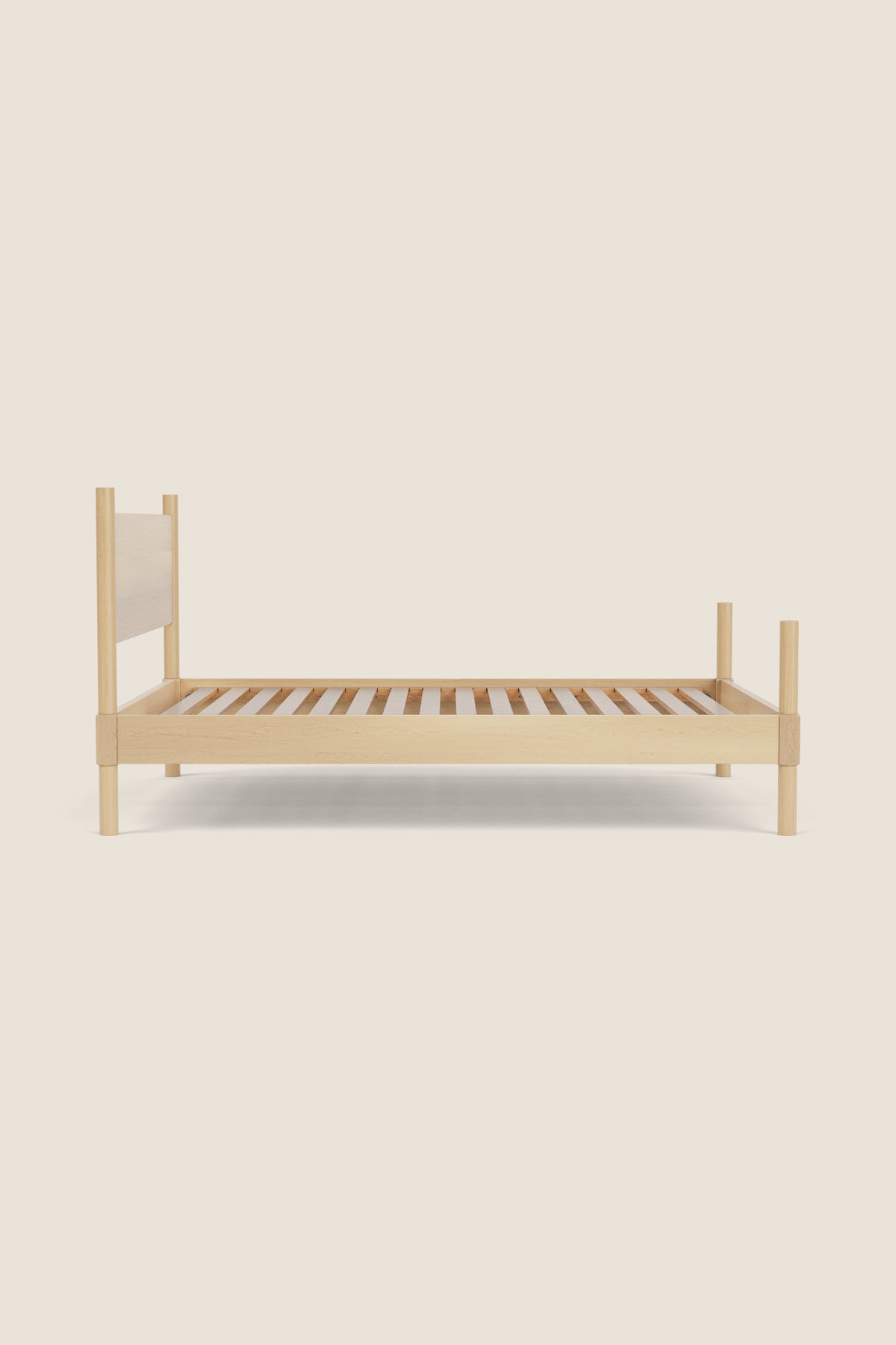 Wooden bed frame with white headboard on a beige background