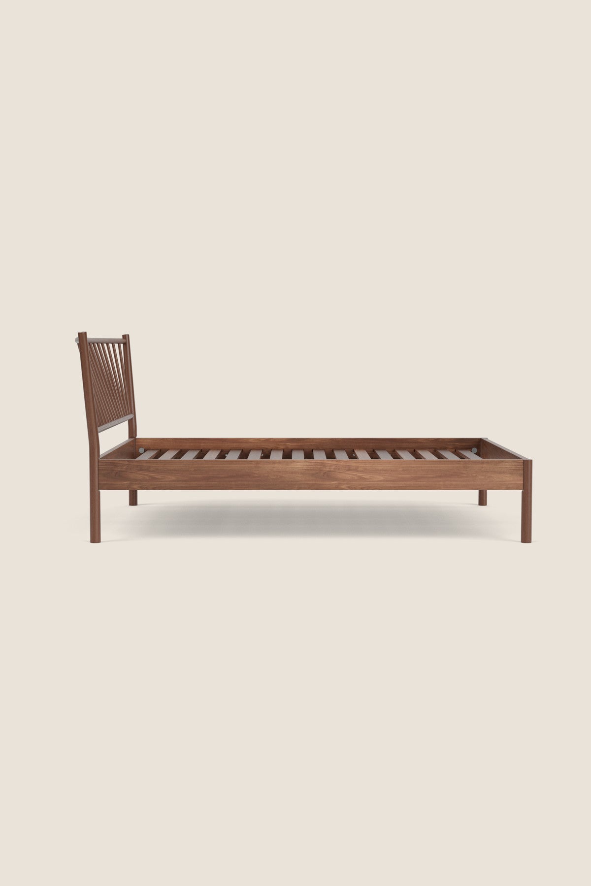 Walnut Chamberlain Bed frame on beige background viewed from the side