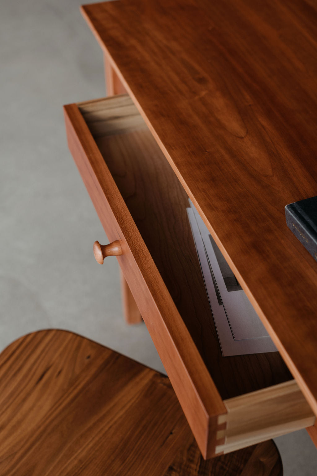 Wooden desk with an open drawer on a neutral background