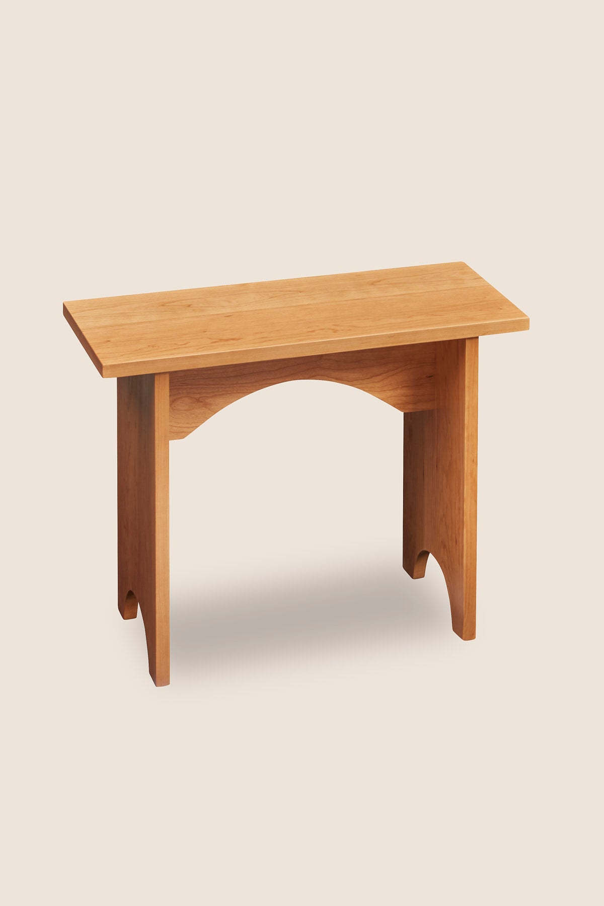 Simple two foot cherry wood bench, built in the Shaker style with arch cutout on both leg boards from Arkansas's Mazhil & Co. Co.