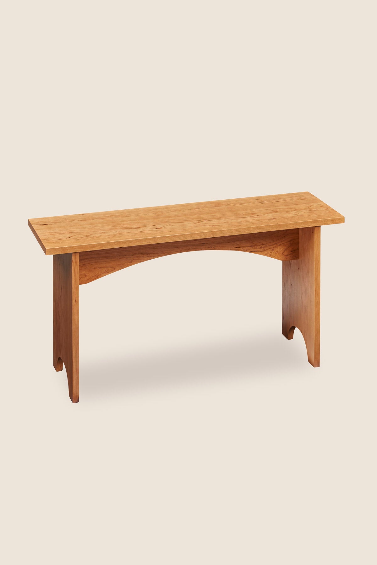 Simple three foot cherry wood bench, built in the Shaker style with arch cutout on both leg boards from Arkansas's Mazhil & Co. Co.