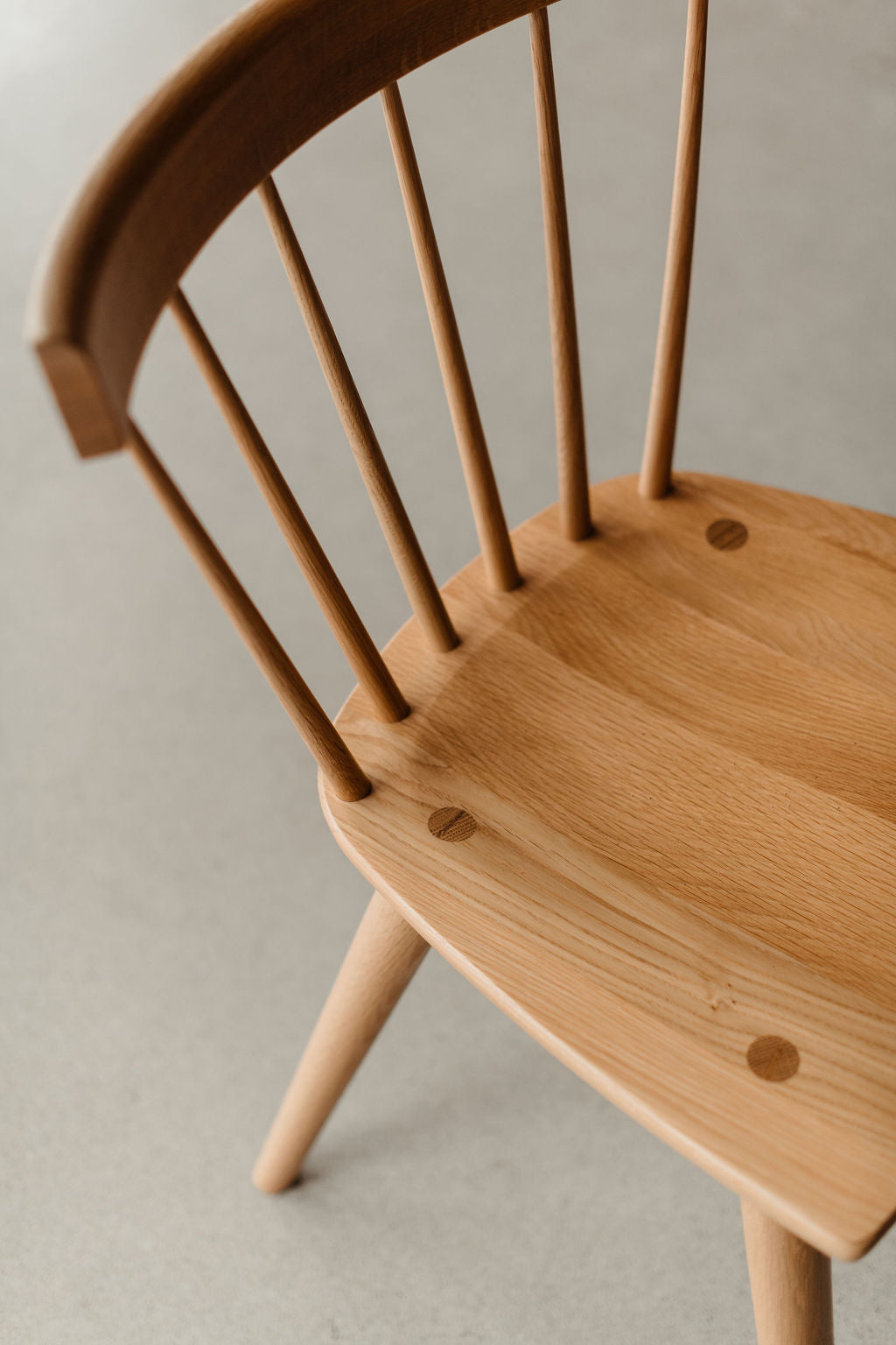 Wooden chair with spindle back on a neutral background