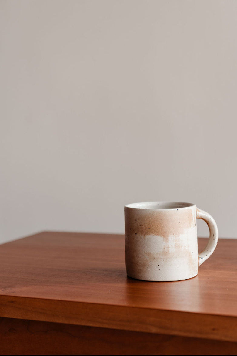 White ceramic mug on a wooden surface with a plain background