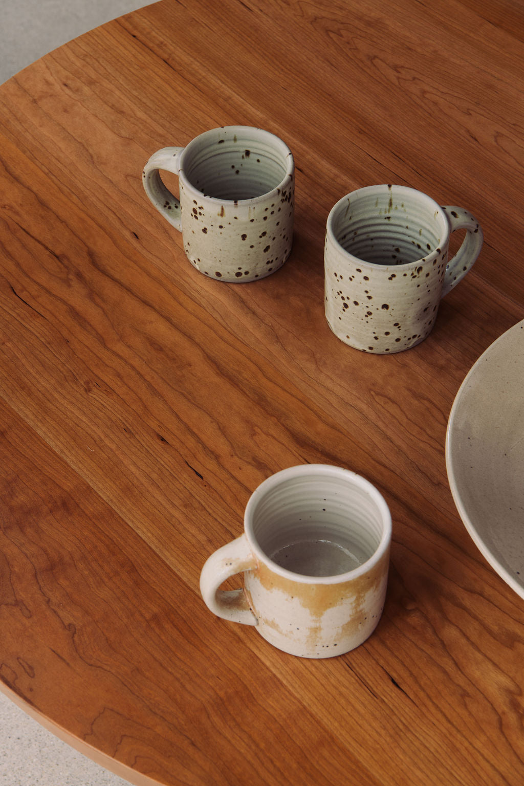 Three ceramic mugs on a wooden surface