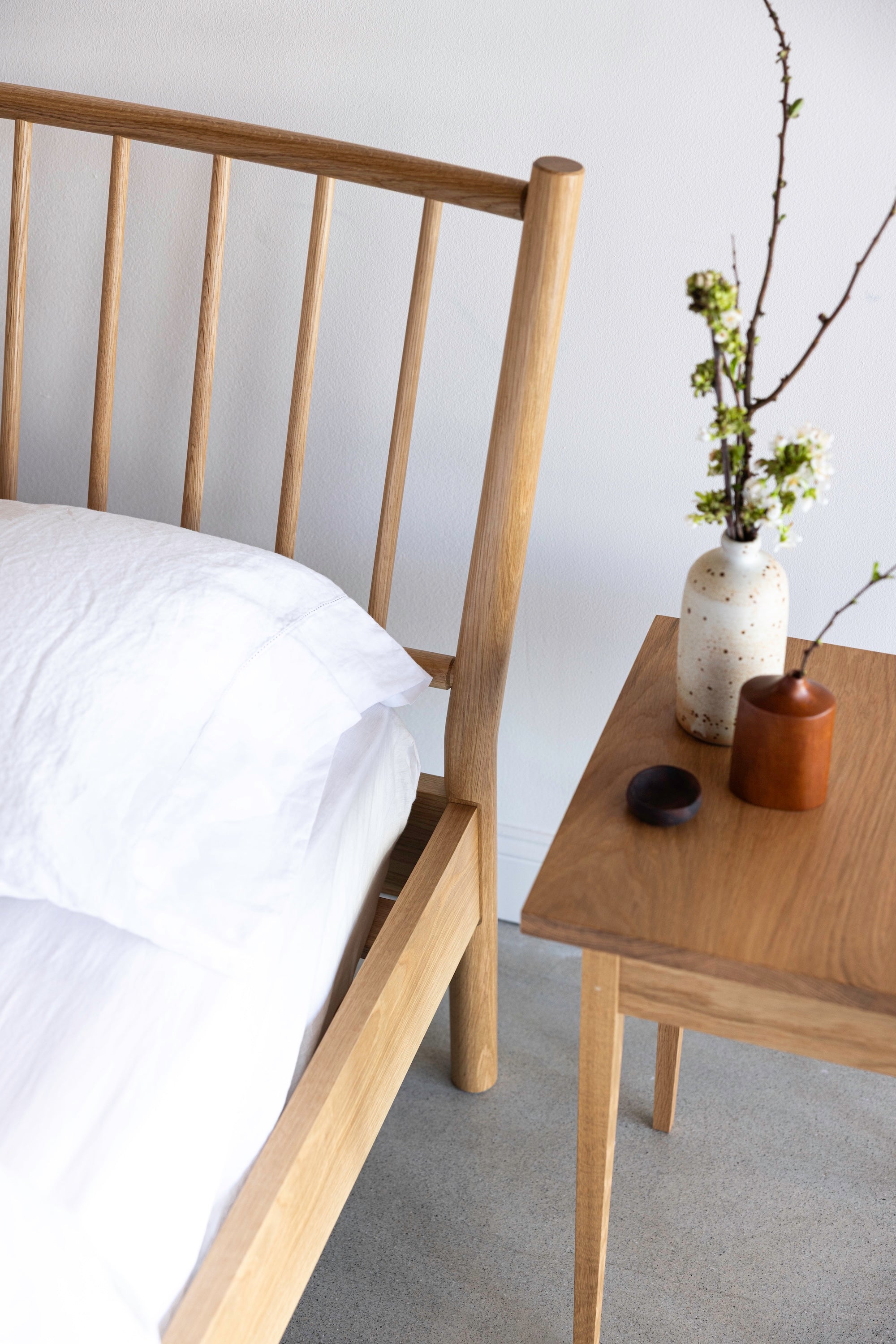 Spindle Chamberlain Bed from Mazhil & Co. next to the Heirloom Side Table with earthy vase styling