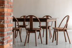 Atlas Dining Table and Chairs in walnut in a modern industrial brick setting from Chilton Furniture in Maine