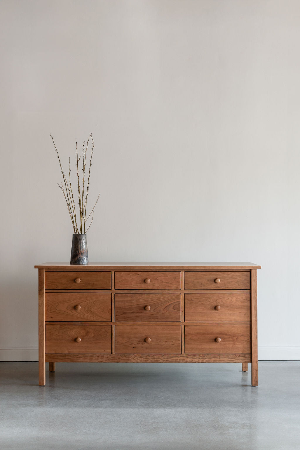 Wooden dresser in modern room with pottery decor