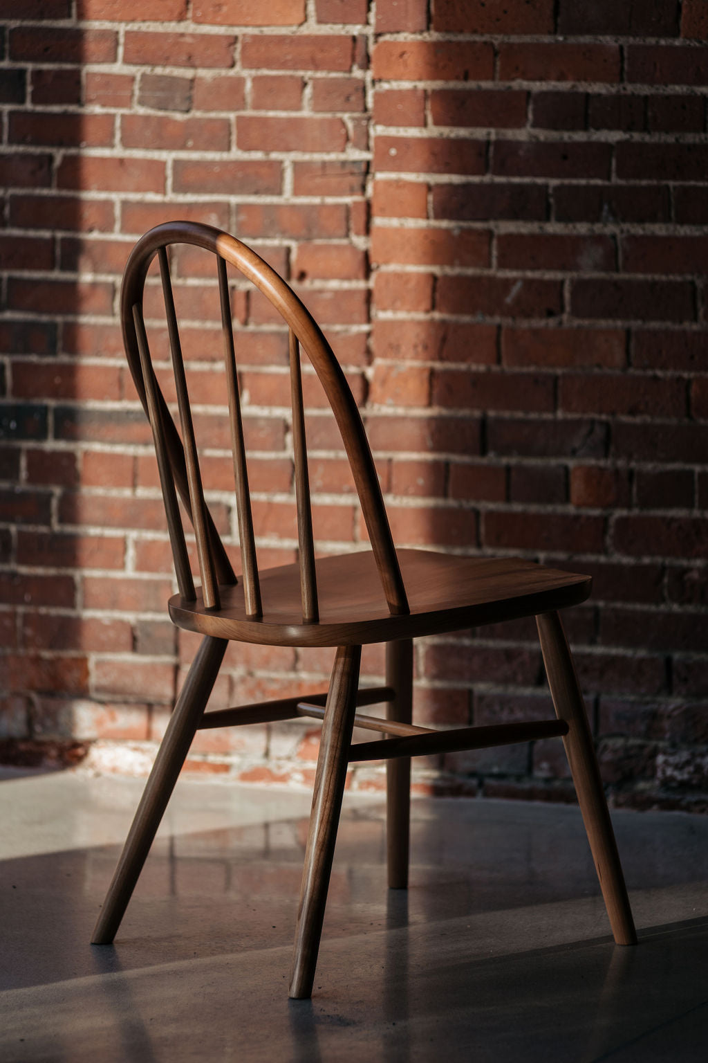Hudson bowback dining chair from Justines Home in front of red brick wall