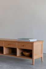 Shaker style storage bench in modern room with books and wooden bowl