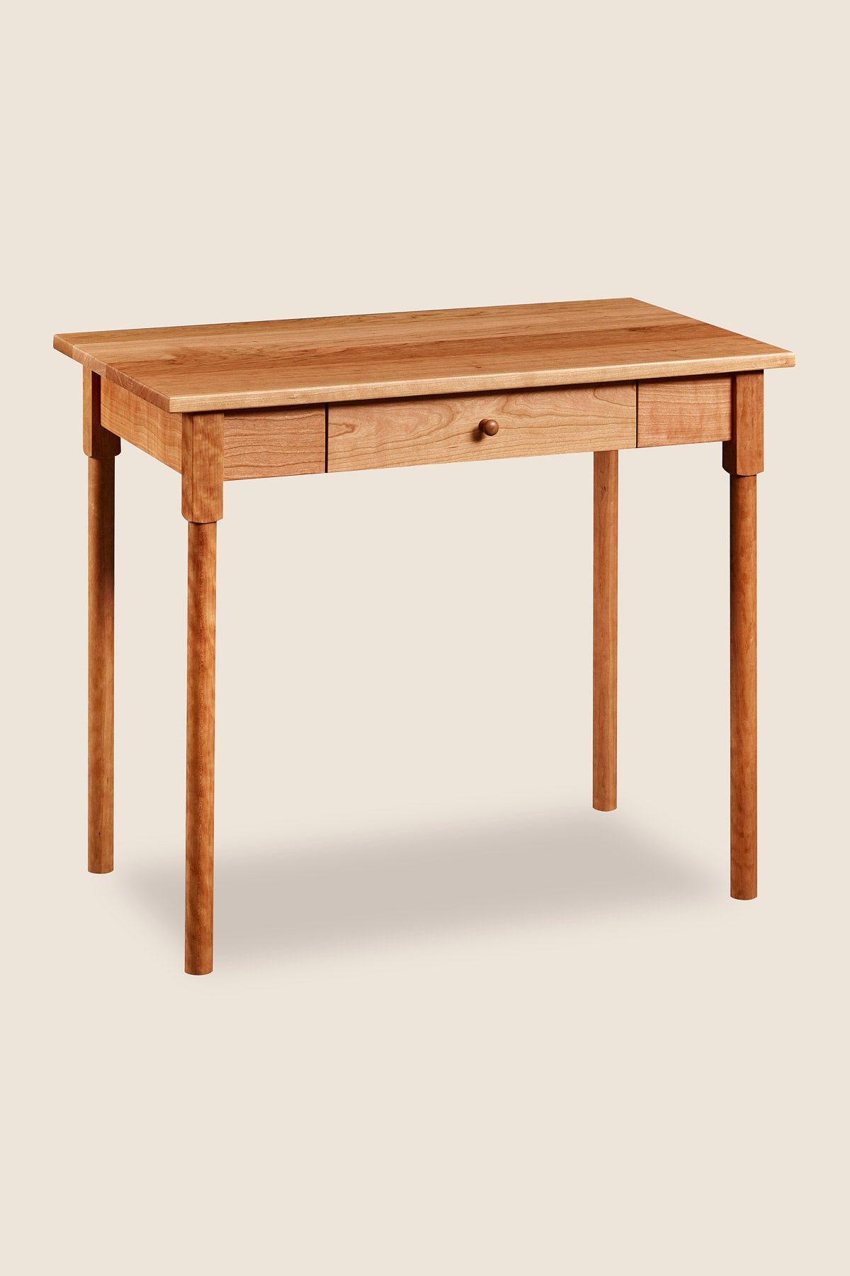 Small shaker inspired writing desk with one drawer and round legs in cherry wood