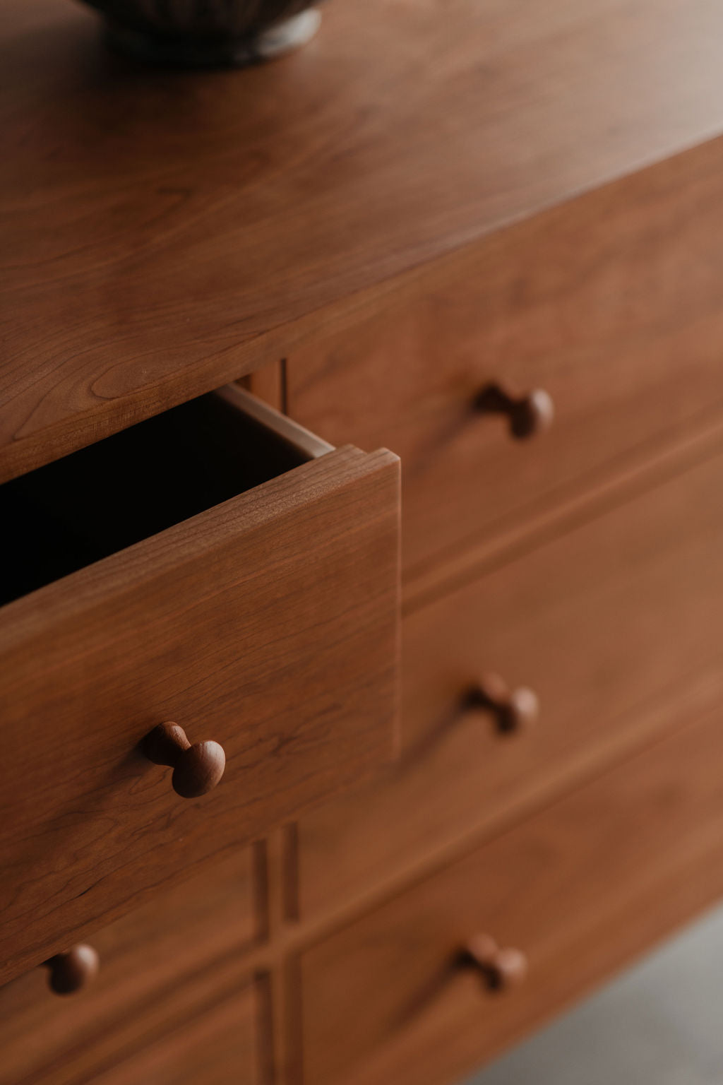 Wooden dresser with open drawer and closed drawers
