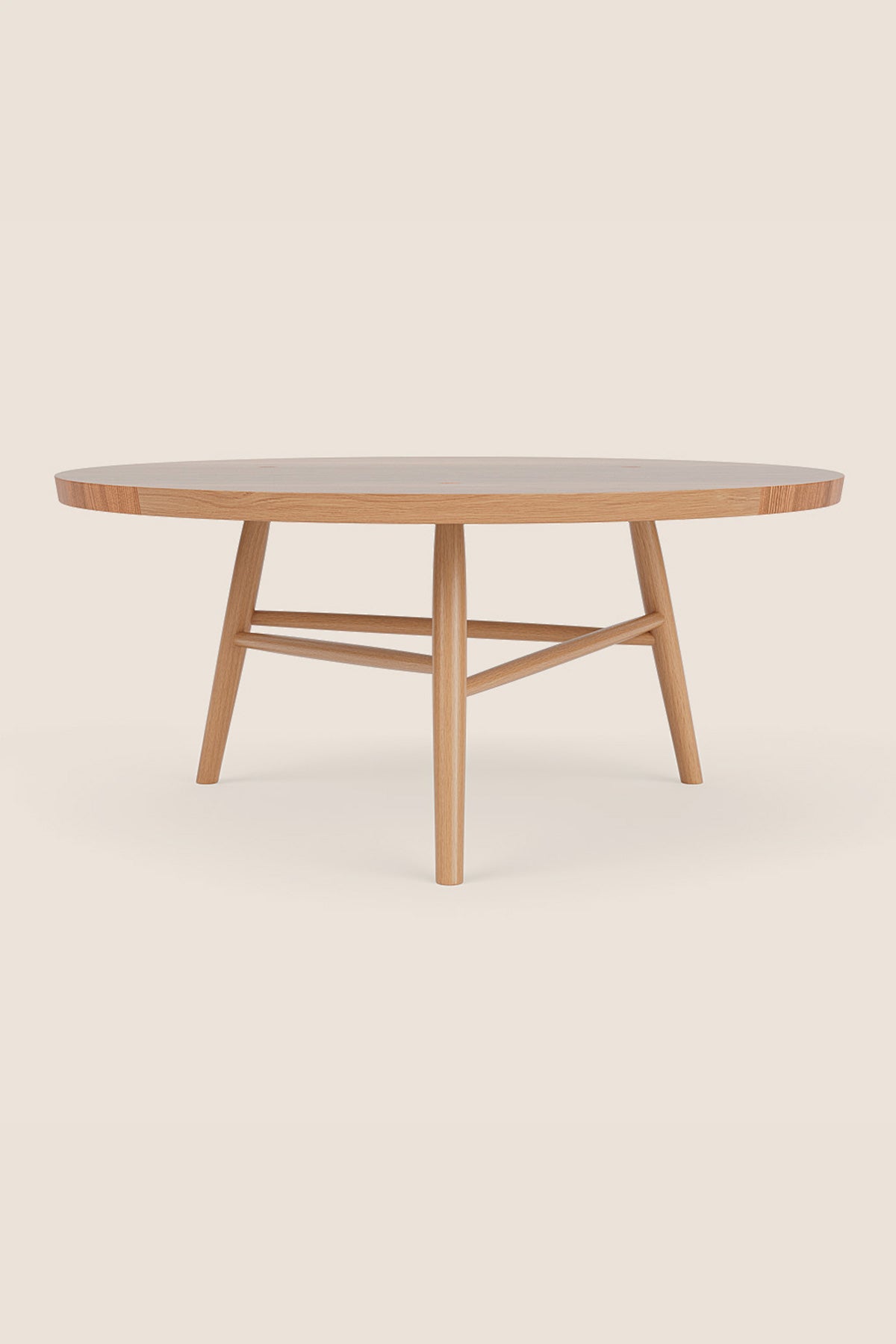 Round wooden Hudson Coffee Table in white oak with three legs on beige background