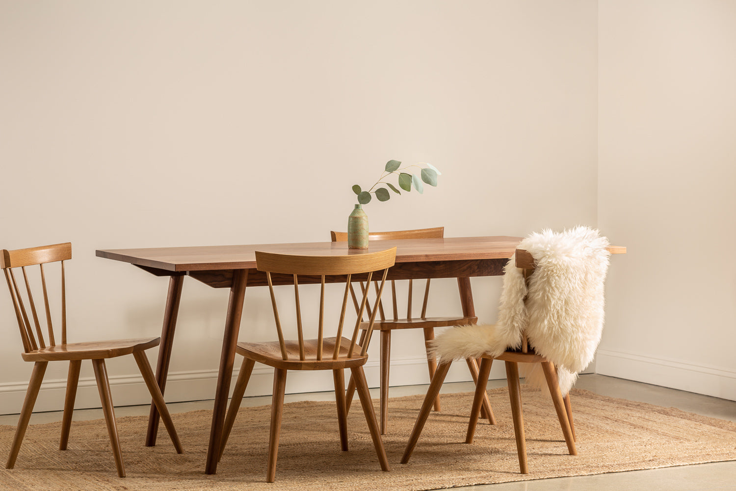 Solid wood dining set with white sheepskin throw on chair