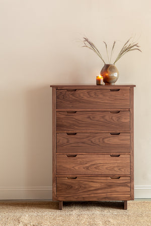 Modern five drawer Foundation Chest in walnut wood with pottery and candle